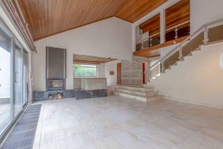 <p><strong>Iconische seventy's villa met uitzonderlijk renovatiepotentieel in hartje Dilbeek</strong></p><p></p><p>Liefhebbers van authentieke seventy's-architectuur zullen meteen gecharmeerd zijn door deze karaktervolle villa. </p><p>Gelegen in een rustige, residentiële buurt in het centrum van Dilbeek, combineert deze woning een unieke retro-uitstraling met royale volumes en een uitzonderlijk renovatiepotentieel. Dankzij de nabijheid van winkels, scholen, openbaar vervoer en andere voorzieningen geniet u hier van een uitstekende ligging.</p><p></p><p>Bij het binnenkomen wordt u verwelkomd in een ruime inkomhal met gastentoilet. De indrukwekkende leefruimte ademt de typische architectuur van de jaren '70, met warme houten accenten, een stijlvolle marmeren vloer, een gezellige open haard en een aparte eethoek. Grote raampartijen zorgen voor een mooie lichtinval en bieden directe toegang tot de zonnige, volledig private tuin.</p><p>De keuken dient vernieuwd te worden en biedt tal van mogelijkheden om een hedendaagse leefkeuken te creëren.</p><p></p><p>Met maar liefst 5 à 6 slaapkamers biedt deze woning uitzonderlijk veel ruimte. Drie slaapkamers bevinden zich op het gelijkvloers/tussenverdiep, terwijl de verdieping plaats biedt aan twee extra slaapkamers en een grote polyvalente ruimte die perfect kan dienen als zesde slaapkamer, bureau, hobbyruimte of speelkamer. Bovendien is er toegang tot een zolder. </p><p>Elke slaapkamer beschikt over een eigen douchekamer, wat het comfort aanzienlijk verhoogt.</p><p>Verder beschikt de woning over een gedeeltelijke kelder, een ruime garage voor twee wagens met automatische poort en een praktische berging.</p><p>De grote aangelegde tuin op een perceel van <strong>11 are 74 centiare</strong> biedt alle rust en privacy die u zich kunt wensen.</p><p></p><p>Extra troeven:</p><ul><li><p>Residentiële topligging in het centrum van Dilbeek</p></li><li><p>Ruim perceel van 11a 74ca</p></li><li><p>Dak vernieuwd in 2011</p></li><li><p>Zonnepanelen</p></li><li><p>Grote bewoonbare oppervlakte met tal van mogelijkheden</p></li><li><p>Authentieke architectuur met unieke 70's uitstraling</p></li><li><p>Ideale renovatiekans voor wie ruimte, karakter en locatie weet te waarderen</p></li></ul><p>Een woning met een uitgesproken persoonlijkheid, royale volumes en eindeloze mogelijkheden om er een eigentijdse droomwoning van te maken.</p>