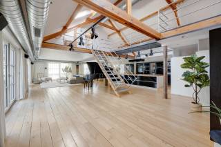 In een historisch gebouw met uitgesproken industrieel karakter aan de Van de Wervestraat, op een boogscheut van Park Spoor Noord en het Antwerpse Eilandje, bevindt zich deze uitzonderlijk ruime en karaktervolle loft. Gelegen in het rustige binnengebied combineert dit unieke eigendom authentieke elementen, royale volumes en een bijzonder flexibele indeling.<br />Via de inkomhal met vestiaire en gastentoilet betreden we de indrukwekkende leefruimte, volledig afgewerkt met parket en gekenmerkt door een aangename plafondhoogte. De ruime industriële keuken is volledig uitgerust met onder meer een stoomoven, hete luchtoven, inductiekookplaat en één gaskookpit, koelkast, diepvries en vaatwasser. Vanuit de leefruimte is er toegang tot twee aangename terrassen, aan de voor- en zijkant van de loft, beide met een gunstige zuidoriëntatie.<br /><br />Een industriële trap leidt naar de mezzanine, waar zich twee ruime slaapkamers bevinden. Aansluitend aan de leefruimte vinden we een praktische was- en technische berging en een royale, centraal gelegen badkamer met groot ligbad, inloopdouche, dubbele lavabo en toilet. De aansluitende inloopdressing met ingemaakte kasten zorgt voor extra comfort en opbergruimte. Vanuit de inkomhal is bovendien een bijkomende slaapkamer bereikbaar, voorzien van dubbele ramen die rechtstreeks toegang geven tot één van de terrassen.<br /><br />Een bijzondere extra troef is het afzonderlijke gedeelte dat via een wenteltrap bereikbaar is. Dit gedeelte beschikt over een eigen leefruimte, (rudimentair) keukenblok, douchekamer met toilet en een ruime kamer op de bovenverdieping kan dit gedeelte perfect functioneren als aparte studio, gastenverblijf, werkruimte of bijkomende slaapvertrekken. Hierdoor leent de loft zich eveneens uitstekend tot co-housing of een combinatie van wonen en werken.<br /><br />Tot slot vormt de ondergrondse autostaanplaats een belangrijke meerwaarde en zorgt deze voor extra comfort op deze centrale Antwerpse locatie. Deze staanplaats is bij aan te kopen.<br />Een unieke loft voor wie op zoek is naar ruimte, industrieel karakter, buitenruimte en tal van indelingsmogelijkheden op een uitstekende locatie nabij Park Spoor Noord en het Eilandje.<br /><br />Interesse in deze unieke loft?<br />Contacteer ons via 03 337 50 70 of info@vbvastgoed.be voor meer info of een bezoek ter plaatse.