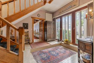 <br />Deze exclusieve burgerwoning, gelegen op een perceel van 604 m², bevindt zich in een rustige, residentiële straat, op wandelafstand van het strand en het centrum van Blankenberge. Met maar liefst 7 slaapkamers, een volledig afgescheiden praktijkruimte met wachtzaal en een bewoonbare oppervlakte van 377 m² biedt deze eigendom uitzonderlijk veel ruimte en tal van gebruiksmogelijkheden.<br />Deze voormalige dokterswoning ademt karakter en authenticiteit. Bij het binnenkomen wordt u meteen verwelkomd door prachtige Spaanse binnendeuren, authentieke middeleeuwse eiken balken en een indrukwekkende inkomhal die de statige uitstraling van de woning onmiddellijk benadrukt.<br />De royale leefruimte straalt klasse en warmte uit dankzij de imposante open haard, de verschillende gezellige zithoeken en de overvloedige natuurlijke lichtinval. Op het gelijkvloers bevinden zich verder een ruime keuken en een volledig afgescheiden praktijkgedeelte met wachtzaal, waardoor de woning zich uitstekend leent voor een vrij beroep of kantoor aan huis.<br />Via de majestueuze trappenhal bereikt u de eerste verdieping, waar de 7 slaapkamers en 2 badkamers zijn ondergebracht. Dankzij de uitzonderlijk brede gevel geniet vrijwel elke ruimte van een aangename lichtinval en een mooi uitzicht op de tuin.<br />De woning is bovendien volledig onderkelderd en beschikt onder andere over een dubbele garage, verschillende bergingen en een technische ruimte.<br />Ook op energetisch vlak scoort deze eigendom verrassend goed. Dankzij de recent geplaatste warmtepomp, de vele zonnepanelen en thuisbatterij behaalt de woning, ondanks de huidige enkele beglazing, reeds een EPC-label C. Er geldt hier bijgevolg geen renovatieverplichting.<br />Met haar unieke karakter, royale volumes en veelzijdige indeling leent deze eigendom zich perfect als ruime gezinswoning, woning met vrij beroep of praktijk, kangoeroewoning, luxueus tweede verblijf of als uitvalsbasis waar de hele familie kan samenkomen. Maar ook voor een uitbating als B&B , is er zeker plaats voldoende. <br /><br />