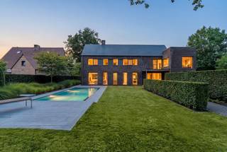 Welkom in deze stijlvolle en instapklare villa waar ruimte, licht en luxe naadloos samenkomen. Gelegen op een prachtig perceel van circa 1.570 m², biedt deze eigentijdse woning alles voor wie comfortabel en sfeervol wil wonen – binnen én buiten.<br /><br />Bij binnenkomst word je verwelkomd in een ruime open inkomhal met gastentoilet en vestiaire. De gelijkvloerse verdieping straalt gezelligheid en klasse uit dankzij de combinatie van grote raampartijen, een open haard, vloeren in Belgische blauwe hardsteen en warme parket. De open keuken is een ware eyecatcher: uitgerust met een royaal kook- en werkeiland, koelkast, oven, vaatwasser, microgolf, keramische kookplaat, grillplaat en zelfs een ingebouwd stoommandje. Aangrenzend vind je een praktische bijkeuken met ingemaakte kasten.<br />De eetruimte biedt voldoende plek voor een grote eettafel en een gezellige leeshoek. Aan de andere kant van de keuken is de zitruimte met open haard en aansluitend bevindt zich een lichtrijke bureauruimte, afgewerkt met maatkasten en zicht op de tuin – ideaal voor thuiswerk in stijl.<br /><br />De eerste verdieping ademt dezelfde hoogwaardige afwerking als het gelijkvloers. De nachthal verbindt vier slaapkamers. De master bedroom beschikt over een eigen dressing en een luxueuze ensuite badkamer met bad, inloopdouche en wastafel, en biedt een prachtig uitzicht op de tuin. De drie kinderkamers zijn stuk voor stuk voorzien van ingebouwde kasten en ingebouwde bureaus. Verder vind je hier een tweede douchekamer, een aparte wasplaats en een afzonderlijk toilet.<br /><br />Via een vaste arduinen trap bereik je de volledig afgewerkte zolderverdieping. Een ideale plek voor een extra slaapkamer(s), speelkamer, hobbyruimte of creatieve studio. Daarnaast is er een afgesloten bergzolder.<br />Tevens kelder aanwezig van ca 60m².<br /><br />De zuidoost gerichte tuin heeft meerdere terrassen en een verwarmd overloopzwembad met waar je op zonnige dagen heerlijk kunt genieten. Aan het zwembad een poolhouse met toilet, kleedruimte, ingebouwde toog en een buitendouche. <br />Achteraan het perceel vind je een ruime, stenen tuinberging met houtopslag én een dubbele carport. Voor de woning is er bovendien voldoende extra parkeergelegenheid.<br /><br />Buitengewone kenmerken: <br />•Hoogwaardige afwerking en veel maatwerk<br />•Grote raampartijen zorgen voor een prachtige lichtinval en tuinzicht<br />•4 slaapkamers en 2 badkamers, mogelijkheid tot extra slaapkamers<br />•Inpandige bergingen en multifunctionele zolderverdieping<br />•Verwarmd overloopzwembad <br />•Regenwaterput aanwezig<br />•Dubbele carport en extra parkeergelegenheid<br /><br />Deze woning combineert modern comfort met een warme, huiselijke sfeer. Ben je op zoek naar een instapklare woning met karakter en ruimte op een toplocatie? Dan is dit jouw nieuwe thuis. Neem vandaag nog contact met ons op voor een bezichtiging.