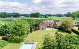 <p><span>Bent u op zoek naar een unieke eigendom waar rust, privacy en ruimte harmonieus samenkomen? Dan zal deze uitzonderlijke landelijke villa in het hart van het glooiende Waaslandse landschap u ongetwijfeld weten te bekoren.</span></p><p><span> </span></p><p><span>Verscholen op de tweede bouwlijn en omringd door prachtige volwassen bomen strekt deze exclusieve eigendom zich uit over maar liefst ruim 2 hectare. De zeldzame combinatie van een idyllische, groene omgeving en een uitstekende bereikbaarheid maakt van dit domein een absolute buitenkans.</span></p><p><span> </span></p><p><span>De belangrijkste troeven in een notendop:</span></p><ul><li><span>Exclusief domein van 21.677 m² met aangelegde tuin, weilanden, zwembad en poolhouse.</span></li><li><span>Toplocatie: uiterst rustig gelegen en toch op slechts 3 minuten van de oprit van de E17, met een vlotte verbinding naar Gent, Antwerpen en Brussel.</span></li><li><span>Prachtige beplanting met waardevolle bomen en een sfeervolle vijver.</span></li><li><span>Zeer ruime villa met een bewoonbare oppervlakte van ca. 500 m².</span></li><li><span>6 slaapkamers en 2 badkamers.</span></li><li><span>Perfecte zuidwestoriëntatie </span></li></ul><p><span> </span></p><p><span>Via de oprijlaan bereikt u deze karaktervolle villa, die in 1979 degelijk werd gebouwd en doorheen de jaren met zorg werd onderhouden, gemoderniseerd en energetisch geoptimaliseerd.</span></p><p><span> </span></p><p><span>Het gelijkvloers verwelkomt u met een royale inkomhal die toegang biedt tot de leefruimtes. De aparte keuken sluit naadloos aan op de eetplaats en de gezellige zithoek met open haard. Daarnaast is er een afzonderlijke bureauhoek voorzien. Via de grote raampartijen heeft u directe toegang tot het zonnige terras en prachtig zicht op groen, waar binnen en buiten moeiteloos in elkaar overvloeien. Verder beschikt deze verdieping over een praktische koele berging en drie garages.</span></p><p><span> </span></p><p><span>Op de eerste verdieping bevinden zich vier ruime slaapkamers en een grote polyvalente ruimte die zich perfect leent als royale master bedroom, praktijkruimte, aparte bureauruimte of conciërge-/nannyverblijf. Dankzij de mogelijkheid om een bijkomende trap met eigen toegang te voorzien, biedt deze ruimte tal van interessante invullingen.</span></p><p><span> </span></p><p><span>De tweede verdieping vervolledigt het geheel met nog twee bijkomende slaapkamers.</span></p><p><span> </span></p><p><span>Het uitgestrekte domein vormt zonder twijfel één van de absolute blikvangers van deze eigendom. De prachtige volwassen bomen creëren een uniek en groen kader, terwijl het vergunde zwembad met poolhouse uitnodigt om volop te genieten van het buitenleven. </span></p><p><span> </span></p><p><span>Dankzij de ideale zuidwestoriëntatie geniet u hier de hele dag van de zon.</span></p><p><span> </span></p><p><span> De weilanden bieden bovendien tal van mogelijkheden voor paardenliefhebbers of voor wie graag omringd wordt door natuur en openheid.</span></p><p><span> </span></p><p><span>Doorheen de jaren werden verschillende energiebesparende investeringen uitgevoerd, waaronder spouw-, dak- en kelderisolatie alsook hoogrendementsbeglazing.</span></p><p><span> </span></p><p><span>Bent u klaar om het unieke karakter en de uitzonderlijke ligging van deze eigendom zelf te ontdekken? Neem dan vrijblijvend contact op voor een bezoek via <span>pieter@axellenaerts.be</span></span><span>.</span></p>