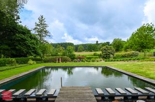 Bestaande uit inkomhal, bureel, living met haard (bio-ethanol, eetplaats, ingerichte keuken, wasplaats, berging, 3 slaapkamers en badkamer. Dubbele carport, tuinberging met sauna, douche en mancave (bar). Tuin met landelijk zicht en ruime zwemvijver. Opp. 4.062m². 48 zonnepanelen + zonneboiler.<br /> 