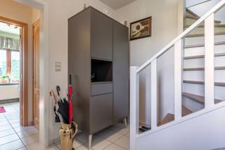 We betreden de woning in de inkomhal, waar we een eerste toilet vinden. Aan de linkerzijde van de hal bevindt zich een handige bureauruimte (9...