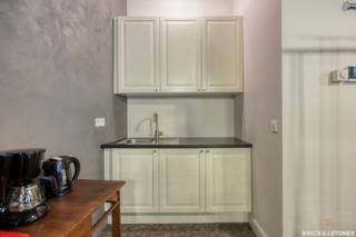 <p>Dit volledig gerenoveerde bedrijfsgebouw (2018) is rustig gelegen in een volledig vergund achtergebouw en biedt tal van mogelijkheden voor professioneel gebruik. Dankzij de doordachte indeling en afzonderlijke voorzieningen leent het pand zich uitstekend voor uiteenlopende activiteiten.<span></span></p>
<p>De ondergrondse verdieping (ca. 127 m²) geniet van opvallend veel natuurlijke lichtinval. Verder beschikt het gebouw over een gelijkvloers (ca. 167 m²), een eerste verdieping (ca. 126 m²) en een tweede verdieping (ca. 119 m²), telkens ingericht als polyvalente ruimte.</p>
<p>Het gelijkvloers, de eerste en de tweede verdieping zijn elk voorzien van een eigen kitchenette en toilet. Daarnaast beschikt iedere bouwlaag over een afzonderlijke warmtebron en eigen energiemeters, wat een flexibel en onafhankelijk gebruik mogelijk maakt.</p>
<p>Op het gelijkvloers bevindt zich bovendien een ruime garage.</p>
<p>De eerste en tweede verdieping zijn momenteel verhuurd, waardoor het gebouw eveneens interessant is voor investeerders die op zoek zijn naar een combinatie van onmiddellijk rendement en eigen gebruik.</p>
<p>Dankzij de veelzijdige indeling is dit pand uitermate geschikt voor kantoren, een groepspraktijk, showroom, polyvalente activiteiten of opslag.</p>