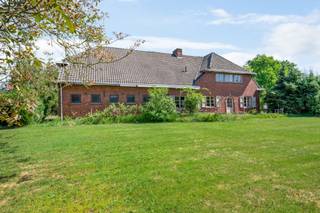 In een doodlopende en bijzonder rustige villawijk, bevindt zich deze riante hoeve op een prachtig perceel van ca. 2.950 m². De ligging is ideaal voor wie rust en ruimte zoekt, maar toch vlot bereikbaar wil wonen: op korte afstand van het centrum van Schilde en Oelegem, het Albertkanaal en de oprit van de E34. Een uitzonderlijke locatie met veel groen, privacy en mogelijkheden.<br /><br />Met een straatbreedte van meer dan 80 meter biedt dit perceel, mits afbraak van het bijgebouw en/of de hoeve, interessante verkavelingsmogelijkheden. Het grote bijgebouw, voorheen deels in gebruik als stallen en nu als opslag, vormt bovendien een enorme troef voor wie nood heeft aan extra ruimte voor een praktijk, kantoor, atelier, zorgwonen of stockage. Ook de inpandige garage met grote zolderruimte biedt verrassend veel potentieel.<br /><br />Via de inkomhal met vestiaire en gastentoilet betreedt men de woning. De ruime woonkamer met authentieke open haard sluit naadloos aan op de eetkamer. De leefkeuken heeft onmiddellijk toegang tot de voorraadkelder en de traphal, en grenst aan een tussenruimte die dienst kan doen als bureau of bijkeuken. Vanuit deze ruimte is er toegang tot de indrukwekkende inpandige garage van ca. 75 m², waar zich een wasplaats met toilet en douche bevindt. Een trap leidt ernaar een ruime zolder, ideaal voor het creëren van extra kamers of een hobbyruimte.<br />Op de eerste verdieping biedt een centrale overloop toegang tot vier ruime slaapkamers en een badkamer ingericht met ligbad, dubbele wastafel, bidet en toilet. De woning beschikt bovendien over een praktische kelder.<br /><br />De tuin strekt zich rondom de gebouwen uit en omvat een royale oprit, een zonnige tuin en een achterliggende speelweide. Dankzij de enorme breedte en oppervlakte van het perceel zijn hier diverse toekomstige mogelijkheden denkbaar, zowel voor particulier gebruik als voor ontwikkeling.<br /><br />De bewoonbare oppervlakte bedraagt 221 m², exclusief zolder en garage. Wanneer deze ruimtes worden meegerekend, biedt de woning meer dan 400 m² aan bruikbare oppervlakte.<br /><br /><strong>Bijzonderheden</strong><br /><strong>+ Uitzonderlijk perceel van ca. 2.950 m²</strong><br /><strong>+ Straatbreedte van meer dan 80 meter met verkavelingspotentieel</strong><br /><strong>+ Inpandige garage van ca. 75 m² met zolderruimte</strong><br /><strong>+ Groot vrijstaand bijgebouw met tal van mogelijkheden</strong><br /><strong>+ Rustige ligging in een doodlopende villawijk nabij E34 en centrum</strong>