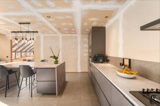 [[ DIT PAND NEEMT DEEL AAN DE ERA OPEN HUIZEN DAG OP 19/9 VAN 13:00 TOT 14:00 ]]
<p><strong>Indeling &amp;amp; ligging</strong><br />Deze eigendom in de Assenedestraat 55 in Bassevelde biedt een combinatie van woonruimte, opslagmogelijkheden en parkeergelegenheid.<br />De woning bevindt zich op een vlot bereikbare locatie in Bassevelde, met het dorpscentrum binnen handbereik. Dankzij de ruime oprit en de 3 aparte garages is er bijzonder veel parkeermogelijkheid op eigen terrein. Bovendien beschikt de eigendom over heel wat extra opslagruimte, ideaal voor wie nood heeft aan ruimte voor materiaal, hobby's of professioneel gebruik.</p>

<p>Op het gelijkvloers wordt u verwelkomd in een zeer lichtrijke leefruimte. De vernieuwde keuken vormt een praktische en moderne basis voor het dagelijkse gezinsleven. Daarnaast beschikt de woning over een afzonderlijke praktijkruimte, waardoor thuiswerken, een vrij beroep of een hobby perfect tot de mogelijkheden behoort.</p>

<p>Op de eerste verdieping bevinden zich maar liefst 4 volwaardige slaapkamers inclusief een ruime slaapkamer met inloopkast op de tweede verdieping. Hierdoor is de woning bijzonder geschikt voor grotere gezinnen of voor wie extra kamers wenst voor bureau, hobby of logies.</p>

<p>Een absolute troef is de grote zuid-gerichte tuin. Deze is toegankelijk via de oprit en biedt volop ruimte om te genieten van zon, rust en privacy. De combinatie van de ruime tuin, meerdere garages en de vele praktische ruimtes maakt deze eigendom bijzonder veelzijdig.<br /><br /><strong>Op zoek naar een ruime woning met veel slaapkamers, praktische bijgebouwen en tal van mogelijkheden? UW DROOMWONING? ZO GEVONDEN!</strong></p>