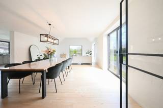 Deze woning van ca. 411 m² bevindt zich op een aantrekkelijke locatie op wandelafstand van de dorpskern van Vosselare. Ze werd volledig geïsoleerd en uitgerust met een lucht/waterwarmtepomp in combinatie met een zonneboiler voor vloerverwarming en warm water. 30 zonnepanelen ondersteunen een duurzaam energieverbruik, terwijl een lucht/luchtwarmtepomp zorgt voor comfortabele koeling in de slaapkamers. Op het gelijkvloers vindt u een inkomhal met gastentoilet en bureauruimte, een leefruimte met open nok die het gevoel van ruimte versterkt, en een volledig uitgeruste keuken met inbouwtoestellen en plaats voor een eetruimte. De keuken sluit aan op een praktische berging, terwijl een tweede inkom toegang biedt tot de was- en strijkruimte. Verder zijn er drie volwaardige slaapkamers, waaronder één met dressing, en een quasi volledig afgewerkte badkamer met dubbele lavabo, ligbad, inloopdouche en toilet. De eerste verdieping biedt twee grote slaapkamers en een vide, ideaal voor een bureau, hobbyruimte of extra leefruimte. De tweede badkamer is voorbereid voor verdere afwerking en er is een apart tweede toilet aanwezig. De tuin beschikt over zonneterrassen, een zwemvijver en een oprit met meerdere plaatsen. <br />​​​​​​<br />EPC: 66kWh (A) / elektriciteit: Conform / CV warmtepomp/ asbestveilig<br /> 