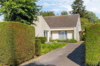 <p>Rustig gelegen in een residentiële woonwijk en omgeven door een groene tuin die volledige privacy biedt, vindt u deze modernistische villa uit 1973. De woning onderscheidt zich door haar tijdloze architectuur, open leefruimtes en grote raampartijen die zorgen voor een overvloed aan natuurlijk licht. De indrukwekkende vide, de karaktervolle centrale haard en de sterke verbinding met de tuin creëren een unieke en aangename woonbeleving.<br /><br />De praktische indeling omvat vier slaapkamers, waarvan twee op het gelijkvloers en twee op de eerste verdieping. Verder beschikt de woning op het gelijkvloers over een badkamer, een technische berging, een wasplaats en een apart gastentoilet. De combinatie van strakke witte gevels, asymmetrische dakvormen en zorgvuldig uitgewerkte volumes verleent de woning een tijdloze uitstraling die vandaag opnieuw bijzonder gegeerd is.<br /><br />Dankzij de solide constructie en de bijzondere architectuur biedt deze villa een unieke kans om een karaktervolle woning volledig naar eigen smaak te moderniseren, met respect voor haar oorspronkelijke ontwerp. Een ideale thuis voor wie op zoek is naar rust, privacy, ruimte en een woning met een eigen identiteit.<br /><br />De prijs betreft een richtprijs. Alle biedingen boven of onder deze prijs worden voorgelegd aan de eigenaars die er al dan niet kunnen op ingaan.</p>
<p>Meer informatie? Contacteer Nicola via 0479 43 30 86<br />Altijd welkom!</p>