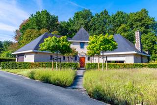 Indrukwekkende villa op 1.590 vierkante meter te Hofstade. Residentieel en rustig gelegen maar zeer goed bereikbaar. Op wandelafstand van het Rijksdomein, de Leuvense Vaart en prachtige natuur. Nabij belangrijke invalswegen en E19. Degelijke constructie met een recent vernieuwd en geïsoleerd natuurleien dak (EPC B). De indeling is bijzonder praktisch zowel op gelijkvloers als op de verdieping. Ruime centrale inkomhal, living van 52 m2, aangrenzende veranda, volledig ingerichte keuken, twee slaapkamers, badkamer, afzonderlijk toilet, technische ruimte, wasplaats en garage. Verdieping met kamer met suite allures, badkamer met douche, tweede kamer met sauna en grote zolder (eventueel nog in te richten). Zonnige tuin rondom het pand met ruim tuinhuis.