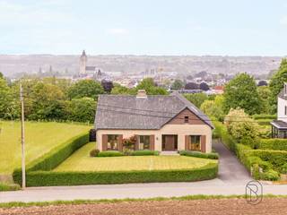 <p>Op een rustige en groene ligging in Oudenaarde bevindt zich deze vrijstaande woning met open zicht op de omliggende natuur. De woning combineert ruimte, comfort en een flexibele indeling, wat ze bijzonder geschikt maakt voor gezinnen of wie wonen en werken wil combineren.<br /><br />Wat maakt dit pand uniek?<br />Op het gelijkvloers word je verwelkomd in een ruime inkomhal met gastentoilet. Links bevindt zich een apart bureau met ingemaakte kasten, ideaal voor thuiswerk of een zelfstandige activiteit. Rechts ligt de ruime leefruimte met open haard en eetplaats, waar gezelligheid centraal staat. Aansluitend is er de keuken en een veranda die zorgt voor extra licht en een aangename verbinding met de tuin.<br /><br />De woning telt vier slaapkamers, waarvan elke kamer (met uitzondering van de master bedroom) voorzien is van een eigen lavabomeubel. Verder is er een verzorgde badkamer.<br />Op het tweede verdiep bevindt zich bovendien een extra gezellige zit- of leefruimte met apart toilet, wat tal van mogelijkheden biedt als ontspanningsruimte, hobbyruimte of extra leefruimte. Daarnaast is er nog een zoldergedeelte en een praktische berging onder het schuine dak.<br /><br />De woning is volledig onderkelderd en beschikt over een garage met poort en meerdere aparte, gemetste bergingen, ideaal voor stockage, provisieruimte of hobby’s.<br /><br />Voor wie is dit ideaal?<br />Deze woning is ideaal voor gezinnen, thuiswerkers of zelfstandigen die op zoek zijn naar een ruime, karaktervolle woning met veel praktische ruimtes, gelegen in een rustige en groene omgeving met toch een vlotte bereikbaarheid.</p>