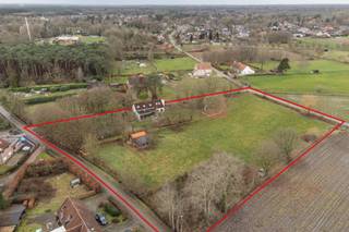 <p>Gelegen op een perceel van ca. 11.000 m² in bevindt zich deze hoeve met weiland en stallen aan de rand van Zoerselbos.<br />De woning combineert authentieke elementen met hedendaags comfort en is onder andere geschikt voor paardenliefhebbers. <br />Absolute rust, privacy en een uniek panoramisch vrij uitzicht zijn enkele troeven van dit eigendom.</p>
<p><strong><span>Hoofdgebouw</span></strong></p>
<p>Inkomhal met gastentoilet en vestiaireruimte - grote leefruimte met veel natuurlijke lichtinval ingedeeld in een zithoek open tot in de nok van het dak en voorzien van een O.H., een tv salon, eetkamer en een zeer ruime open en volledig geïnstalleerde keuken. De keuken is maatwerk en voorzien van Amerikaanse koelkast, een aanrecht en een groot kookeiland met zitruimte voorzien van een werkblad in Belgische blauwe natuursteen, ruime spoelbak - extra groot gasfornuis met 6 pitten, dubbele oven en dubbele dampkap. Aansluitend is er een berging en toegang tot de kelder.<br />Zowel vanuit de zithoek als de keuken is er via grote raampartijen zicht en toegang tot het terras en de tuin.</p>
<p>Op het gelijkvloers bevindt zich de hoofdslaapkamer met houtkachel. De ensuite badkamer is uitgerust met een ligbad, dubbele lavabo, inloopdouche en toilet. Daarnaast is er een aparte dressing. Via het schuifraam is er toegang tot het terras in bankirai.</p>
<p><span><strong>Verdieping</strong></span></p>
<p>De mezzanine staat in verbinding met de woonkamer. Een home office met zicht op de tuin is hier perfect mogelijk.</p>
<p>Op deze verdieping bevinden zich verder twee ruime slaapkamers. De badkamer is voorzien van een ligbad, lavabo en toilet. De plafonds reiken tot in de nok wat zorgt voor een ruimtelijk gevoel.</p>
<p><span><strong>Kelder</strong></span></p>
<p>De kelder van 28 m² biedt extra bergruimte.</p>
<p><span><strong>Buitenruimte en paardenfaciliteiten</strong></span></p>
<p>Het achterliggende perceel biedt diverse mogelijkheden en beschikt over een stalling voor twee tot drie paarden.</p>
<p>Achter de boomgaard bevindt zich een ruime carport van 7m x 10,5m met extra garage.</p>
<p><span><strong>Bijgebouw</strong></span></p>
<p>Het bijgebouw van Heritage Buildings is voorzien van een haard en kan dienen als ontspanningsruimte, lounge, hobbyruimte of werkplek.</p>
<p><span><strong>Bijzonderheden</strong></span></p>
<p>Vloerverwarming op aardgas (glvl) en combinatie verwarming/airco op verdieping (radiatoren mogelijk) - raamwerk in hout en aluminium - dubbele beglazing - overal massieve eiken plankenvloer - EPC 232 kWh/m² - UC 20250819-0003666936-RES-1 - elektriciteit niet conform - woning is asbestvrij - Vg-Ag-Gvv-Gvkr-Gmo-Gworg.</p>