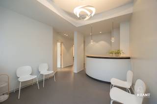 <p><strong>Moderne Instapklare Praktijkruimtes met Designafwerking op Toplocatie</strong></p><p> </p><p>Welkom in deze volledige ingerichte praktijkruimte (tweedelig) van ca. 82 m², afgewerkt met oog voor detail, comfort en functionaliteit. Een ideale opportuniteit voor (para)medische beroepen of vrije beroepen die op zoek zijn naar een professionele en instapklare werkomgeving.</p><p> </p><p>De praktijk werd in 2018 grondig gerenoveerd met nadruk op kwaliteit en design. U komt binnen in een stijlvolle wachtzaal met hoogwaardige afwerking en een opvallende designlamp (Artemide Pirce Micro Suspension) als subtiele blikvanger. De moderne secretariaatsbalie vormt het centrale aanspreekpunt en zorgt voor een professionele ontvangst van uw cliënten.</p><p> </p><p>De twee ruime, geluidsgeïsoleerde kabinetten genieten van aangenaam daglicht. Het kabinet aan de voorzijde beschikt over een elektrisch bedienbaar rolgordijn. Beide ruimtes zijn uitgerust met designmeubilair van Bulo en Kartell, handenwassers, onderzoekstafels en meerdere aansluitpunten voor bekabeld internet. Hier werd werkelijk gedacht aan comfort, discretie en efficiëntie.</p><p> </p><p>Verder is er een praktische keuken met ingebouwde koelkast en voldoende kastruimte, een rolstoeltoegankelijk patiëntentoilet en een afzonderlijk diensttoilet.</p><p> </p><p>Op technisch vlak scoort deze praktijk bijzonder sterk: verwarming en airco via een energiezuinige Daikin warmtepomp, ventilatiesysteem D en een combinatie van TL- en LED-verlichting zorgen voor een aangenaam binnenklimaat. De videoparlofoon met deuropening vanuit beide kabinetten en de balie verhoogt het gebruiksgemak en de veiligheid. Bovendien is de volledige praktijk toegankelijk voor mindervaliden.</p><p> </p><p>Een privatieve kelder, bereikbaar met lift, biedt extra bergruimte.</p><p> </p><p>Strategisch gelegen aan de Ruggeveldlaan in Deurne, met uitstekende zichtbaarheid en bereikbaarheid. De tramhalte bevindt zich recht tegenover de praktijk, wat zorgt voor een vlotte verbinding naar Antwerpen en omliggende gemeenten. Parkeermogelijkheden zijn ruim aanwezig in de directe omgeving, inclusief twee mindervalidenplaatsen op slechts 50 meter. Voor bezoekers geldt bovendien: de eerste twee uur per dag gratis parkeren, nadien aan een minimaal tarief.</p><p> </p><p><strong>TROEVEN</strong></p><p>+ Volledig instapklaar en recent gerenoveerd (2018)</p><p>+ Mogelijkheid tot het overnemen van hoogwaardige designmeubels</p><p>+ Twee geluidsgeïsoleerde, lichtrijke kabinetten</p><p>+ Energiezuinige Daikin warmtepomp en ventilatiesysteem D</p><p>+ Volledig rolstoeltoegankelijk</p><p>+ Privatieve kelder bereikbaar met lift</p><p> </p><p>Bent u op zoek naar een representatieve en professioneel uitgeruste praktijkruimte op een commerciële topligging in Deurne? Dan is dit een unieke kans.</p>