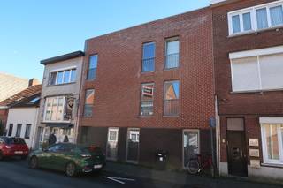 <p>Aan de rand van het centrum, op wandelafstand van het station, wacht dit bijzonder praktisch en verrassend comfortabel appartement u op. Gelegen op de eerste verdieping van een kleinschalige residentie (bereikbaar via trap), combineert deze woonst functionaliteit met hedendaags wooncomfort – en dat met een knipoog.<br />Binnenkomen doet u via een inkomhal met apart toilet en handige bergplaats. De volledig geïnstalleerde keuken staat paraat voor zowel culinaire hoogstandjes als snelle pastasessies op maandagavond. Aansluitend vindt u een ruime en lichtrijke leefruimte met plaats voor een royale zithoek én een volwaardige eetplaats – ideaal voor gezellige diners of een avondje languit ontspannen.<br />Het appartement beschikt over twee slaapkamers, beide reeds voorzien van kastruimte (uw kleerkast kan dus met pensioen), en een verzorgde badkamer. Het terras vormt een aangename buitenplek voor uw ochtendkoffie of een zonnig aperitief.<br />Ook op technisch vlak scoort deze woonst sterk: zeer degelijk geïsoleerd, voorzien van vloerverwarming én een regenwaterput. Energiezuinig wonen zonder in te boeten aan comfort – goed voor het milieu én voor uw energiefactuur.<br />Op het gelijkvloers hoort bovendien een ruime privatieve garagebox bij het appartement. Geen parkeerzoektocht, geen natte boodschappen in de regen – gewoon comfortabel thuiskomen. Provisie algemene kosten: €15/maand. Onmiddellijk beschikbaar.<br />Bent u dé kandidaat waar wij op wachten? Wacht dan niet tot iemand anders er met uw plek vandoor gaat! <br />Meld u vandaag nog aan via onze website als kandidaat en zet de eerste stap richting nieuwe kansen, frisse uitdagingen en een toekomst om enthousiast van te worden.</p>