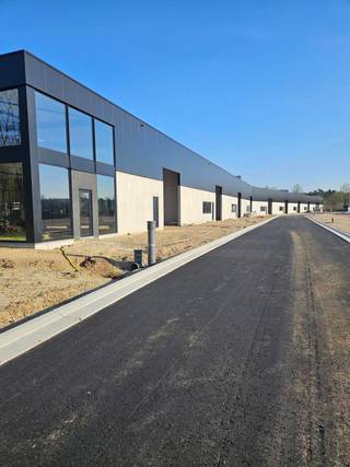 De units worden gebouwd in een duurzame staalconstructie en voldoen aan brandklasse C, waardoor ze zowel robuust als veilig zijn. Gelegen vlakbij de E34 en het kanaal Schoten-Dessel, is dit een plek waar jouw onderneming letterlijk én figuurlijk kan groeien.
Met oppervlaktes van 353 m² tot 379 m², zijn de units volledig configureerbaar volgens jouw noden. De buitenwanden worden onderaan uitgevoerd in 3 meter geïsoleerde betonpanelen en bovenaan in kwalitatieve sandwichpanelen, wat zorgt voor uitstekende isolatie en een moderne uitstraling. Van productie tot opslag, van kantoor tot atelier – deze site biedt de flexibiliteit én voorzieningen om met je bedrijf mee te groeien.
Troeven van dit toekomstgericht bedrijfsproject:
Volledig moduleerbare units – mogelijkheid tot gebouw op maat
Dakrandhoogte van 8 meter en vrije hoogte van 6,4 meter – ruime mogelijkheden voor stapeling of mezzanine (inbegrepen)
Elektrische, geïsoleerde sectionaalpoorten (4 m x 4,5 m) en parkeerplaatsen voor de deur
Optie voor kantoorruimte en/of loskades
Dak in steeldeck met isolatie en lichtstraat met geïntegreerde rook- en warmteafvoer
Groot raam met zicht op natuur en waterpartij voor extra licht en beleving
Duurzaam & comfortabel werken:
Zonnepanelen en groene zones geïntegreerd in het projectontwerp
1 parkeerplaats per 100 m² magazijn ter beschikking
Casco oplevering met alle nutsleidingen tot in de unit (incl. glasvezel)
Regenwaterput van 10.000 liter per unit
Buitenschrijnwerk in thermisch onderbroken aluminium voor optimale energie-efficiëntie
Vloer in polybeton na bespreking met de koper
Optionele afwerking op maat: verlichting, HVAC, sanitair, elektrische installatie, beveiliging, vloerafwerking, ...
Oplevering voorzien Q1 2026
Meer info omtrent beschikbaarheden en oppervlaktes en prijzen beschikbaar op kantoor.
Oppervlaktes en afmetingen zijn indicatief en gebaseerd verkregen informatie.