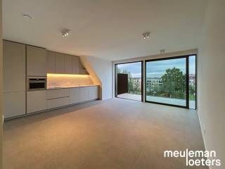 Au cœur de Veldegem, découvrez ce spacieux appartement de trois chambres situé au deuxième étage de la résidence moderne Delphine, construite en 2026. L’alliance d’une architecture contemporaine, de matériaux de haute qualité et de technologies énergétiquement performantes fait de ce logement un lieu agréable à vivre.<br /><br />L’entrée s’ouvre sur un lumineux espace de vie doté de grandes fenêtres, véritable atout pour la luminosité. La cuisine attenante, entièrement équipée avec des appareils haut de gamme SMEG, comprend un lave-vaisselle, une plaque à induction avec hotte intégrée, un combiné réfrigérateur-congélateur et un four à convection. Un espace de rangement pratique avec branchements pour lave-linge et sèche-linge complète cet ensemble.<br /><br />L’appartement dispose de trois grandes chambres doubles, idéales pour une famille, un bureau à domicile ou une salle de loisirs. La salle de bain séparée est finie avec modernité et équipée d’une douche à l’italienne, d’un double lavabo, d’une armoire murale et d’un radiateur porte-serviettes.<br /><br />Un véritable plus est la grande terrasse offrant une vue dégagée remarquable !<br /><br />Côté stationnement et rangement, ce bien offre de nombreux avantages. Un garage privé est inclus dans la location, équipé d’une porte automatique, d’un éclairage et de l’électricité. Une borne de recharge pour véhicules électriques peut également y être installée. Un second garage est disponible en location optionnelle pour 75 € par mois. Les vélos peuvent être rangés en toute sécurité dans le local commun prévu à cet effet.<br /><br />L’appartement est déjà équipé de luminaires et de rails pour rideaux.<br /><br />Grâce à ses caractéristiques à énergie neutre et à ses technologies modernes, vous profitez d’un cadre de vie durable, axé sur le confort et l’efficacité.