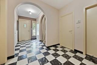 Gelegen op een idyllisch perceel van maar liefst 2.224 m², verscholen in het weelderige en rustgevende groen, presenteren wij deze royale vrijstaande villa. Met een bewoonbare oppervlakte van circa 230 m² en een bosrijke tuin biedt dit eigendom een zeldzame basis voor wie op zoek is naar ultieme rust, privacy en de unieke kans om een droomwoning volledig naar eigen hand te zetten. De statige architectuur met de warme rode baksteen en de omringende volwassen bomen zorgen bij aankomst direct voor een warm en exclusief gevoel.
De binnenzijde van de villa kenmerkt zich door een uiterst doordachte indeling met een zee aan ruimte. Op het gelijkvloers bevindt zich, naast de keuken en leefruimte met prachtig zicht op de omliggende natuur, een praktische kantoorruimte. Deze kamer leent zich uitstekend als thuiswerkplek of als volwaardige extra slaapkamer op de begane grond. Op de bovenverdieping biedt de woning ruimte aan vier comfortabele, volwaardige slaapkamers, waardoor het pand perfect beantwoordt aan de noden van een groot gezin.
Een absolute en unieke troef van dit vastgoed is de riante aanpalende werkplaats. Deze multifunctionele ruimte biedt tal van architectonische en professionele perspectieven. Dankzij de royale oppervlakte en de directe verbinding met het hoofdgebouw transformsert u deze zone moeiteloos tot een high-end praktijk voor een vrij beroep, een inspirerend kunstenaarsatelier, of een stijlvol thuiskantoor met eventueel een aparte toegang voor cliënten.
De woning beschikt momenteel over een EPC-score F, wat een renovatieverplichting met zich meebrengt. Dit is echter de uitgelezen kans voor de meerwaardezoeker. De solide constructie en de royale volumes nodigen uit om deze villa te moderniseren naar de allerhoogste hedendaagse normen van luxe, comfort en energie-efficiëntie. Met de juiste visie transformeert u dit object in een ecologisch en esthetisch meesterwerk. Laat u betoveren door de ongekende potentie en de magnifieke groene setting van deze villa en maak van dit project uw eigen exclusieve parel.