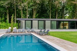 Dans l'exclusif Schotenhof se trouve cette villa majestueuse et luxueusement rénovée sur un magnifique terrain d'environ 4 162 m². La propriété allie le charme d'une villa classique au confort et à la finition d'une rénovation totale contemporaine.<br /><br />La maison a été entièrement rénovée en 2022 et offre aujourd'hui une expérience de vie particulièrement élégante avec des volumes généreux, des matériaux de haute qualité, des accents chaleureux et une grande attention aux détails. L'allée longue, la verdure mature et l'emplacement discret procurent immédiatement une sensation exceptionnelle de calme et d'intimité.<br /><br />Rez-de-chaussée:<br />La villa accueille par un hall d'entrée impressionnant avec un sol en damier en pierre naturelle, de hauts plafonds et un escalier monumental. Les espaces de vie sont finis avec du parquet en chêne en point de Hongrie, des meubles sur mesure, un éclairage indirect et une cheminée élégante. De grandes baies vitrées apportent beaucoup de lumière et offrent une vue sur le jardin, la piscine et le poolhouse.<br /><br />À côté se trouvent une salle à manger élégante et une cuisine luxueuse avec un grand îlot de cuisine en pierre naturelle foncée, un grand mur d'armoires et des appareils intégrés.<br /><br />Premier étage:<br />Le vaste palier donne accès aux pièces privées. La chambre principale respire le calme et le confort et dispose d'une salle de bains luxueuse en pierre naturelle, d'une baignoire, d'une douche à l'italienne et de meubles sur mesure. En outre, il y a des chambres supplémentaires, une deuxième salle de bains et un espace supplémentaire pouvant servir de salon, de bureau, de dressing ou de chambre à coucher.<br /><br />Deuxième étage:<br />Sous le toit se trouve un étage supplémentaire complet avec chambre et salle de bains privative. Idéal comme étage d'invités, chambre d'adolescent, suite au pair ou espace principal supplémentaire.<br /><br />Sous-sol:<br />La villa est entièrement sous-solée et divisée en différents espaces pratiques, dont une salle technique, une buanderie et des espaces de rangement.<br /><br />Poolhouse:<br />À l'arrière du jardin se trouve un poolhouse moderne d'environ 100 m², entièrement orienté vers la piscine et le jardin paysager. Grâce aux grandes baies vitrées et à l'aménagement ouvert, l'intérieur et l'extérieur se fondent harmonieusement.<br /><br />Le poolhouse offre un espace polyvalent généreux avec des installations pour kitchenette et climatisation, et convient comme espace de détente, bureau, cabinet, salle de sport, logement pour invités ou logement pour personnes nécessitant des soins. À côté se trouve un espace bien-être avec sauna KLAFS, douche à l'italienne avec sunshower et toilettes séparées.<br /><br />Jardin et environnement extérieur:<br />Le terrain a été aménagé en tenant compte de la vie privée, du calme et de l'expérience. La maison dispose de nombreuses possibilités de stationnement, d'un garage double séparé, de terrasses généreuses, d'une piscine, d'une terrasse ensoleillée et d'un magnifique cadre verdoyant avec des arbres matures et des haies.<br /><br />Remarques:<br />- Situé dans l'exclusif Schotenhof sur environ 4 162 m²<br />- Rénovation totale en 2022<br />- Surface de plancher utilisable selon le certificat PEB: 440 m²<br />- Étiquette PEB C: 219 kWh/m² an<br />- Installation électrique conforme<br />- Entièrement sous-solée<br />- Finition luxueuse avec pierre naturelle, meubles sur mesure et parquet en chêne<br />- Piscine avec poolhouse moderne d'environ 100 m²<br />- Espace bien-être avec sauna KLAFS, sunshower et douche à l'italienne<br />- Convient pour profession libérale, logement pour personnes nécessitant des soins, bureau ou logement pour invités