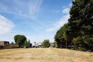 Dit recent verkavelde perceel bevindt zich in de Zuivelstraat te Assenede, een landelijke nieuwe straat waar reeds enkele mooie moderne woningen werden gebouwd. De straat is doodlopend en geniet daardoor van een privaat en veilig karakter en toch is de bereikbaarheid naar o.m. de expresweg en de R4 erg goed. Het perceel zelf is lot 2 van een kleinschalige verkaveling naar 2 loten. Dit lot heeft een straatbreedte van ca. 18m en een gemiddelde diepte van ca. 64,7m. Er dient min. 3m bouwvrije strook naast de woning voorzien te worden, dan rest er een gevelbreedte voor de nieuw te bouwen woning van iets meer dan 11m. De maximale bouwdiepte op het gelijkvloers is 15m, op de verdieping 12m. Dit impliceert dat er bewoonbare oppervlakte van ca.300m2 kan gerealiseerd worden, al dan niet vermeerderd met een kelderverdieping en een extra ruimte onder een hellend dak. Het dak mag variëren van 0° tot 45°. Een bijgebouw van max. 40 vierkante meter in de tuin is eveneens toegelaten. De inrit is een gezamenlijke oprit voor zowel lot 1 als lot 2 zodat beide loten gemakkelijk op en af hun perceel kunnen manoeuvreren. Deze bouwgrond leent zich uitermate goed voor grote gezinnen of voor kopers die op zoek zijn naar veel ruimte voor een mooi architecturaal ontwerp! Meer informatie: 0485/321.842