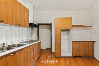 Voor meer info en foto’s, surf naar www.swevers.be – Ontdek dit te renoveren handelshuis met appartement aan de Koolmijnlaan 6 in Beringen. Deze eigendom uit 1899 combineert een handelsruimte met een ruime woongelegenheid en biedt tal van mogelijkheden voor ondernemers die wonen en werken willen combineren of voor investeerders. Een extra troef is de praktische achtertoegang, die zorgt voor een vlotte bereikbaarheid. Het handelspand beschikt over een bureauruimte/handelsruimte van 23,43 m² met uitbreiding tot 14,69 m², een keuken, een afzonderlijk toilet en een opslagruimte, ideaal voor diverse commerciële activiteiten. Het appartement omvat een inkomhal, een woonkamer, een keuken, een badkamer op het eerste verdiep. Op de tweede verdieping bevinden zich nog drie slaapkamers, waardoor de woning geschikt is voor een gezin of een combinatie van wonen en thuiswerken. Daarnaast zijn er een kelder en zolder die extra opslagruimte bieden. De eigendom ligt op een perceel van 1 are en biedt dankzij de renovatiemogelijkheden alle kansen om het pand volledig naar eigen smaak en hedendaags comfort in te richten. De centrale ligging is een bijkomend pluspunt. De snelweg ligt op 3,5 km, openbaar vervoer op 80 meter, scholen op 600 meter, restaurants op 250 meter, winkels op 700 meter en recreatiemogelijkheden op 1,8 km. Zo geniet u van een vlotte bereikbaarheid en alle voorzieningen binnen handbereik. Voor meer informatie, bel 011 255 155. Bron bewoonbare oppervlakte: EPC – verslag.