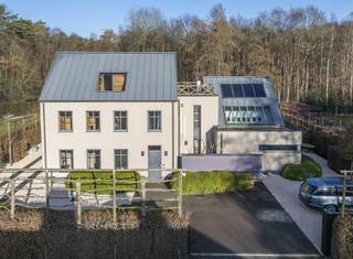 <p><strong>Quares by Trevi presenteert: Puur vakantiegevoel en privacy in een knappe villa aan het natuurgebied</strong></p>
<p>Geïnspireerd op de stijl van Piet Boon, kenmerkt deze villa zich door strakke architectuur, technische snufjes en kwaliteitsvolle, hoogwaardige materialen. Tijdloos design, mooie zichtlijnen en veel lichtinval zorgen voor rust en een direct vakantiegevoel. Topmaterialen zoals Corian, eik en notenhout sieren de woning. Domotica, warmtepompen, airco en een vingerafdrukscanner bieden modern comfort.</p>
<p><strong>De belangrijkste troeven op een rij:</strong></p>
<ul>
<li><strong>Toplocatie:</strong> Rustige, doodlopende straat aan een natuurgebied, vlak bij de Golf van Keerbergen.</li>
<li><strong>Wellness:</strong> binnenzwembad met jetstream & aansluitende badkamer, zwemvijver en luxe poolhouse.</li>
<li><strong>Ruimte:</strong> 6 slaapkamers, meerdere dakterrassen, home cinema en grote, droge kelder.</li>
<li><strong>Techniek:</strong> Uitgerust met warmtepompen, airco, domotica en camerabewaking.</li>
</ul>
<p><strong>INDELING</strong></p>
<p><strong>Gelijkvloers:</strong> Inkomhal met vestiaire en gastentoilet; wasplaats; bureau; royale leefruimte met open haard en tuinvisie; home cinema/eetkamer; inpandig west-terras met open haard. De luxe leefkeuken heeft een eiland, Gaggenau-toestellen, wijnkoeler en Quooker. Aansluitend ligt de wellnessruimte met binnenzwembad (ionisatie & jetstream, perfect werkend, nu afgedekt als relaxruimte) die baadt in het licht, en een badkamer met vrijstaand bad, douche en toilet.</p>
<p><strong>Kelder:</strong> Grote, droge kelder met actieve ventilatie, verdeeld in 6 ruimtes (ideaal als mancave, fitness, wijnkelder) plus de technische installaties.</p>
<p><strong>Eerste verdieping:</strong> Vijf slaapkamers met massieve parket en airco. De master bedroom heeft een en-suite dressing en privé-dakterras. Verder zijn er drie slaapkamers (waarvan één met terras), een zeer grote kamer boven het zwembad, apart toilet en een badkamer met ligbad, douche, bidet en dubbele lavabo.</p>
<p><strong>Tweede verdieping:</strong> Zesde slaapkamer of studio met toegang tot een groot dakterras achteraan en een terras vooraan.</p>
<p><strong>Buitenruimte:</strong> Volledig omheind perceel met automatische poort. Oprit voor 4 auto's, garage en berging. Het poolhouse heeft een douche, toilet, berging en overdekt terras met infraroodverwarming. De tuin biedt diverse terrassen, een zwemvijver met circulatiepomp en een origineel tuinhuis waarin een boom geïntegreerd is.</p>
<p>Heb je interesse? Maak een afspraak met Tinne Schotsmans op <strong>0477 60 21 99</strong> of via <strong>tinne.schotsmans@quares-trevi.be</strong>.</p>
<p></p>