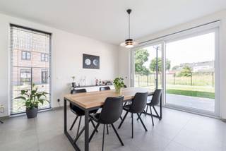 <p><span>Ligging<br /></span><span>Deze woning situeert zich in een nieuwe, rustige woonwijk in Oosteeklo. <br />Het dorpscentrum en de school liggen op wandelafstand. <br />Eeklo, Assenede en Ertvelde zijn vlot bereikbaar. <br />Via de N49 en de R4 rijd je snel richting Gent, Antwerpen en de kust. <br />Ideaal voor gezinnen die rust zoeken, dicht bij alles.<br /><br /></span><span>Instapklare nieuwbouwwoning met 3 slaapkamers, carport en zonnige tuin<br /></span><span>Deze moderne woning combineert een strakke architectuur met een praktische indeling. <br />De lichte gevelsteen, het platte dak en het zwarte schrijnwerk geven het geheel een tijdloze uitstraling. <br />De bewoonbare oppervlakte bedraagt ca. 155 m².<br /><br />Via de inkomhal kom je bij het gastentoilet en de trap naar boven. <br />De open leefruimte is het hart van de woning. <br />Zithoek, eethoek en keuken lopen mooi in elkaar over. <br />Grote raampartijen en een schuifraam zorgen voor veel licht en een open zicht op de tuin. <br />De keuken is volledig uitgerust.<br />De wasplaats met berging biedt plaats voor de warmtepomp en de wasmachine. <br />De nachthal geeft toegang tot drie ruime slaapkamers. <br />De badkamer en een apart toilet vervolledigen de verdieping.<br /><br />Achteraan is de omheinde tuin met terras en naast de woning een carport met oprit en plaats voor tweede wagen.<br /><br /></span><span>Extra<br /></span><span>/ warmtepomp<br />/ ventilatiesysteem C<br />/ hoogwaardige afwerking</span></p><p><span><br />*prijs exclusief kosten<br /><br /></span><span>Troeven<br /></span><span>/ nieuwbouw, instapklaar<br />/ 3 slaapkamers<br />/ energiezuinig<br /><br /></span></p>