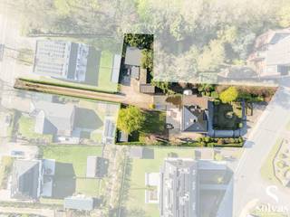 Ontdek de unieke charme van Villa Rozenberg, een karaktervolle woning uit circa 1936, gelegen in het hart van Zomergem op een uitzonderlijk perceel van maar liefst 2.150 m².<br /><br />Deze statige eigendom combineert authentieke elementen met hedendaags comfort en biedt tal van mogelijkheden dankzij de aanwezigheid van twee garages en een ruim magazijn van 70m², bereikbaar via een aparte oprijlaan langs de Kleitstraat.<br /><br />Bij het betreden van de woning word je verwelkomd in een indrukwekkende inkomhal die meteen de sfeer zet. Het gelijkvloers omvat een lichtrijke keuken, een gezellige leefruimte met haardvuur, een bureauruimte, een tweede knusse zithoek, evenals een praktische wasplaats/berging en een ruime, droge kelder.<br /><br />Op de eerste verdieping bevinden zich vier volwaardige slaapkamers en een ruime badkamer, uitgerust met inloopdouche, dubbele lavabo en toilet. De zolderverdieping biedt een prachtige vijfde slaapkamer met airco. Op deze verdieping werd ook een tweede badkamer gecreëerd met opnieuw een inloopdouche, dubbele lavabo en toilet. <br /><br />De zonnige, zuidwest georiënteerde tuin vormt een oase van rust, waar je in alle sereniteit kan genieten van het buitenleven. Daarnaast beschikt de tuin over een tuinhuis met overkapping en een gezellige ontspanningsruimte.<br /><br />Villa Rozenberg is een zeldzame opportuniteit voor wie op zoek is naar ruimte, karakter en een centrale ligging, gecombineerd met tal van mogelijkheden voor wonen en werken.