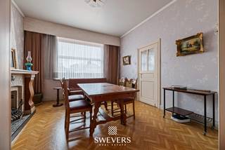 Voor meer info en foto’s, surf naar www.swevers.be – Op zoek naar een woning met karakter en renovatiemogelijkheden? Aan de Heerbaan 145 in Koersel bevindt zich deze halfopen bebouwing uit 1938 met 139 m² bewoonbare oppervlakte, twee ruime slaapkamers en een perceel van maar liefst 860 m². Op het gelijkvloers vind je een inkomhal, een gezellige zitkamer van 16,80 m², een eetkamer en een aparte keuken van 16,80 m². De veranda biedt uitzicht op de tuin en kan na renovatie een aangename ontspanningsruimte worden. Verder zijn er een wasruimte, afzonderlijk toilet en een ruime aangebouwde garage van 33 m². De eerste verdieping telt twee volwaardige slaapkamers van elk 16,80 m² en een badkamer die in 2021 werd vernieuwd. Extra opbergruimte is beschikbaar in de kelder van 10,50 m² en op de ruime zolder van circa 48 m² grondoppervlakte. Het noordwestelijk georiënteerde perceel van 860 m² biedt volop mogelijkheden voor een terras, speelruimte of moestuin. De woning beschikt over rolluiken, ramen uit 2004 en verwarming op mazout. De ligging is praktisch, met openbaar vervoer op 300 meter, scholen op 750 meter en winkels op circa 2 kilometer. De snelwegen bereik je op ongeveer 5,2 kilometer. Deze te renoveren woning vormt de ideale basis voor wie een thuis volledig naar eigen smaak wil creëren. Voor meer informatie, bel 011 255 155. Bron bewoonbare oppervlakte: EPC – verslag.