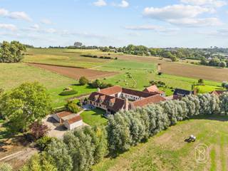 <p>Te midden van de prachtige glooiende landschappen van de Vlaamse Ardennen bevindt zich deze uitzonderlijk charmante en volledig gerenoveerde vierkantshoeve.</p><p>De hoeve verwelkomt u via een ruime parking en een verzorgde toegang tot de sfeervolle binnenkoer. Rondom vindt u prachtig aangelegde terrassen en tuinen die perfect aansluiten bij het karakter van het gebouw en waar rust en natuur centraal staan, genietend van prachtige uitzichten. Binnen wordt u meteen verrast door de warme en gezellige geïnstalleerde leefkeuken met eiland, volledig uitgerust met kwalitatieve toestellen, een praktische bijkeuken en berging met koelcel, inkom en ontvangsthal, gezellige zithoek en op het verdiep, 4  slaapkamers met 3 bad- en/of douchekamers.</p><p>In de bijgebouwen bevinden zich 5 perfect onderhouden karaktervolle kamers, waarvan 3 duplexkamers, elk met eigen toilet en badkamer (douche en lavabo).</p><p>Een absolute blikvanger is de polyvalente ruimte met open haard, gepolierde betonvloer en een indrukwekkend zichtbaar dakgebinte. Dankzij de directe toegang tot de terrassen vormt deze ruimte de perfecte setting voor bijeenkomsten of seminaries.</p><p>Unieke opportuniteit: mogelijkheid tot overnemen van een goed draaiende B&amp;B, seminarieruimte, inclusief diverse randactiviteiten(mogelijkheid overname via aandelen)</p><p>Troeven van deze eigendom:<br />* Perfect onderhouden en volledig gebruiksklaar, met oog voor energeizuinigheid (zonnepanelen, nieuwe brander)<br />* Authentieke charme gecombineerd met modern comfort<br />* Dubbele beglazing en geïsoleerde daken<br />* Geautomatiseerde installaties<br />* Uitzonderlijke ligging in de natuur van de Vlaamse Ardennen</p><p>Meer info of bezoek via info@immobeguin.be</p>