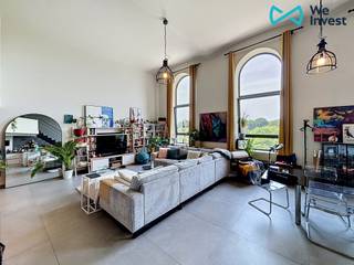 ***A LOUER *** TUBIZE - Splendide loft d'une superficie de +/- 150 m² situé à +/- 10 minutes à pied de la gare et de toutes commodités.<br /><br />Situé au 2ème étage, il se compose comme suit : un hall d'entrée, un vaste living lumineux avec une cuisine ouverte entièrement équipée (frigo, taque vitrocéramique, four, hotte, lave-vaisselle, évier, et meubles de rangement), une chambre de +- 10 avec sa salle de douche, une grande buanderie et un WC séparé. En mezzanine : un palier de nuit menant à deux chambres de +/- 16 m² et +/- 11,5 m² ainsi qu’une salle de bain de +/- 7 m² (meuble double vasque, baignoire, miroir et WC) <br /><br />Conforts : PEB "A" (51 kWh/m².an) ; Chauffage au gaz par le sol ; VMC double flux ; Châssis double vitrage ; Cave.<br /><br />Loyer : 1.175 euros/mois. Charges des communs : 120 euros/mois + 10€/personne (provision d’eau).<br /><br />Disponible le 01/07/2026<br /><br />Contact : 02.355.42.20 ou tubize@weinvest.be ou Julie au 0472.53.66.84