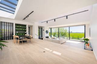 Dit uitzonderlijke eigendom is gelegen op een prachtig perceel van ca. 3.000 m² en combineert de charme van een authentieke hoeve met de elegantie van een moderne, architecturaal geïntegreerde aanbouw. Het resultaat is een lichtrijke, warme en uiterst karaktervolle woning die uitblinkt in klasse en comfort.<br /><br />Indeling & leefruimtes<br /><br />Bij het betreden van de woning komt u via de inkomhal met vestiaire in de royale leefruimte met grote glaspartijen, die een overvloed aan natuurlijk licht binnenlaten en rechtstreeks toegang geven tot het ruime, deels overdekte terras. Hier geniet u van een panoramisch open zicht op de groene omgeving.<br /><br />De volledig ingerichte leefkeuken, afgewerkt met kwalitatieve materialen, is een echte blikvanger en biedt aansluitend een praktische bijkeuken met voorzieningen voor het plaatsen van een wasmachine en droogkast.<br /><br />Slaapkamers & badkamers<br /><br />De master bedroom beschikt over veel ingemaakte kasten en een prachtig open uitzicht, met aansluitend een ruime badkamer. Daarnaast vindt u op het gelijkvloers nog een tweede volwaardige slaapkamer met ingemaakte kasten, een gezellige tv-kamer/bureau en een multifunctionele kelderruimte.<br /><br />Op de verdieping bevinden zich drie bijkomende ruime slaapkamers, een apart toilet en een badkamer.<br />Buitenruimte & extra’s<br />Een absolute troef van dit eigendom is het verwarmde buitenzwembad van ca. 17,5 m lang – perfect geïntegreerd in de tuin en afgewerkt met hoogwaardige materialen. De royale oprit geeft toegang tot de zeer ruime inpandige garage.<br />Verder geniet deze woning van talrijke extra’s die bijdragen aan het ultieme wooncomfort:<br />Twee open haarden<br />Domoticasysteem<br />Alarmsysteem en camerabewaking<br />Gedeeltelijke vloerverwarming<br />Ruime oprit met veel autostaanplaatsen buiten de garage<br /><br />Een exclusieve woning die authenticiteit en modern comfort moeiteloos combineert. Dankzij de lichtrijke ruimtes, hoogwaardige afwerking, het adembenemende uitzicht en het unieke zwembad is dit een eigendom dat garant staat voor een uitzonderlijke woonervaring.
