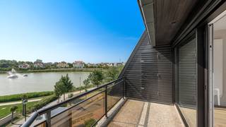 Spacious and sun-filled apartment with panoramic views over the Zegemeer, located in the villa residence Maracana. The entrance hall features a cloakroom and guest toilet. The generous living area, comprising a lounge and dining space, opens onto the southwest-facing terrace and enjoys breathtaking views of the Zegemeer. The fully equipped open-plan kitchen offers all modern comforts and appliances, with an adjoining practical storage room/laundry area.<br />The master bedroom includes an en-suite bathroom with bathtub, double washbasin and toilet. In addition, there are two full-sized bedrooms and an extra shower room. All bedrooms provide direct access to the sunny terrace, where one can enjoy the evening sun in complete peace and quiet.<br />Optional purchase of a garage box within the residence, accessible via the Georginapad. The apartment further benefits from two private cellar storage rooms and an exclusive right of use of the 75 m² rooftop terrace/solarium. Communal bicycle storage available.