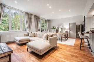 Looking for a spacious apartment for sale in Halle, just outside Brussels? This energy-efficient apartment (EPC B) with 2 bedrooms, 2 shower rooms, a sunny terrace and a lift is set in green, park-like surroundings.
The property combines peace and quiet, nature and excellent accessibility. The train station is close by, and via the Ring road (R0) you can reach Brussels in 15 to 20 minutes. This apartment in Halle is ideal as an investment or as your own home.
Located on the first floor, the apartment offers plenty of privacy, abundant natural light and a beautiful view of the greenery. It has been finished with exceptional taste. The entrance hall is fitted with cupboards and a seating area. Most of the other rooms also have built-in cupboards, providing remarkable storage space. The recent, fully equipped open kitchen with oven, microwave, induction hob and a large oak breakfast bar opens onto a bright living area with parquet flooring.
The apartment originally had 3 bedrooms. Two of them were combined into one very large bedroom, so today there are 2 generous bedrooms with parquet flooring and views of the greenery. The second bedroom is also perfect as a children's room, guest room, hobby room or home office. If you later want 3 bedrooms again, the original layout can easily be restored. The apartment also has 2 fully tiled shower rooms, each with a walk-in shower, 2 separate toilets and a laundry room.
The sunny, covered terrace is not overlooked and looks out onto the trees. It is the perfect place to enjoy the sun in complete peace. The apartment is move-in ready, in excellent condition and has an EPC B rating.
Looking for a move-in ready, energy-efficient apartment for sale in Halle, near Brussels, with a terrace, tranquillity and investment potential? This is a rare opportunity. Contact us today to arrange a viewing