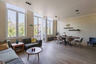 Karaktervol appartement met ruim terras op toplocatie<br /><br />Op een uitzonderlijke locatie aan de Groenplaats, met uitzicht op het Hilton Hotel en op wandelafstand van de Grote Markt, de Meir en de Wilde Zee, bevindt zich dit charmante appartement in een kleinschalige residentie.<br /><br />Via de stijlvolle inkomhal bereikt u het appartement op de eerste verdieping. De ruime en lichtrijke leefruimte met parketvloer biedt een prachtig uitzicht op de Groenplaats. Aansluitend bevindt zich de luxueus uitgeruste open keuken, voorzien van alle hedendaagse comfort, een kookeiland en een gezellige ontbijthoek.<br /><br />Vanuit de keuken leidt een korte trap naar het lager gelegen deel. Hier bevindt zich een praktische bureauruimte in de gang, met toegang tot het rustig gelegen terras. Op dit niveau vindt u tevens een ruime slaapkamer met een ensuite badkamer, uitgerust met een lavabo, douche en toilet en een wasplaats.<br /><br />Via een kleine trap bereikt u het hoger gelegen deel, waar zich een tweede ruime slaapkamer bevindt met een ensuite dressing. Daarnaast is er een volledig uitgeruste, royale badkamer.<br /><br />Een absolute troef van dit appartement is het gezellige en rustig gelegen terras, waar u in alle privacy kunt genieten van een oase van rust, midden in het bruisende stadscentrum.<br /><br />Daarnaast is er de mogelijkheid om een staanplaats aan te kopen in de naastgelegen residentie voor € 35.000.