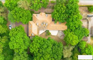 <p><strong>Riante energiezuinige villa met binnenzwembad en maximale privacy</strong></p>
<p>Op zoek naar luxe, ruimte en rust? Deze exclusieve villa, gelegen op een residentieel en rustig perceel van 2.477 m², biedt het allemaal. Met een bewoonbare oppervlakte van maar liefst 540 m² geniet je hier van comfortabel en energiezuinig wonen in een groene, discrete omgeving.</p>
<p>De woning werd gebouwd in 2006 en is voorzien van alle hedendaagse comfort. De ruime woonkamer met open leefkeuken baadt in natuurlijk licht en vormt het hart van het huis. De gehele gelijkvloerse verdieping is voorzien van gepantserd glas. Verder beschikt de villa over 5 volwaardige slaapkamers en 4 badkamers – ideaal voor grotere gezinnen of wie graag gasten ontvangt.</p>
<p>Voor ontspanning hoef je de deur niet uit: het luxe binnenzwembad zorgt voor een permanent vakantiegevoel. Ook thuiswerken wordt een plezier dankzij de grote kantoorruimte. Bovendien is er een aparte studio, perfect als gastenverblijf, praktijkruimte of voor inwonende hulp.</p>
<p>Buiten geniet je van een overdekt terras en een prachtig aangelegde tuin die volledige privacy garandeert. De dubbele garage maakt het plaatje compleet.</p>
<p>Bij het betreden van deze riante en energiezuinige villa komt u via de inkomhal meteen in de ruime leefruimte terecht. De woonkamer met gezellige zithoek en gashaard vloeit naadloos over in de eetplaats en de open leefkeuken, die voorzien is van alle hedendaags comfort – een ideale plek voor wie graag kookt en gasten ontvangt.</p>
<p>Een stijlvolle glazen wand scheidt de woonkamer van het binnenzwembad. Hoewel het zwembad momenteel buiten gebruik is, zijn alle technieken aanwezig om dit eenvoudig opnieuw in werking te stellen. Momenteel wordt de ruimte gebruikt als fitnessruimte, maar ze biedt ook andere mogelijkheden zoals wellness of hobbyruimte. Aansluitend bevinden zich een technische ruimte en een welnessgedeelte met sauna, douche en toilet. Een trap leidt hier naar een grote polyvalente ruimte op de verdieping, uitgerust met airconditioning en momenteel ingericht als kantoor.</p>
<p>Op het gelijkvloers is ook een ruime dubbele garage met toegang tot de kelder. Tussen de keuken en garage bevindt zich een tweede trap die leidt naar een studio, bestaande uit twee slaapkamers en een badkamer met douche, lavabo en toilet – ideaal als gastenverblijf of voor inwonende hulp.<br /><br />Vanuit de centrale inkomhal vertrekt een derde trap naar de bovenverdieping, waar u de masterbedroom vindt, uitgerust met parketvloer, airconditioning en gashaard. De master beschikt over een aanpalende dressing en een eigen badkamer met bad, douche en toilet. Daarnaast zijn er nog twee extra slaapkamers met parket en een aparte badkamer met ligbad, lavabo en toilet. Een gastentoilet is eveneens voorzien op het gelijkvloers.</p>
<p><strong>Buitenleven in alle comfort</strong></p>
<p>Grenzend aan de woonkamer bevindt zich een ruim overdekt terras, uitgerust met elektrische rolschermen en terrasverwarming – ideaal om het hele jaar door van buiten te genieten. Een tweede terras ligt aan het binnenzwembad. De aangelegde tuin rondom de woning biedt volledige privacy en rust. Verder beschikt het domein over een carport en een professioneel alarmsysteem.</p>
<p>Een unieke combinatie van ruimte, luxe en rust. Klaar om jouw nieuwe thuis te worden?</p>