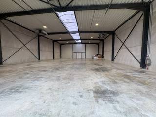 Deze instapklare industriehal van 360 m² is uitstekend gelegen op bedrijvenpark Nagelsberg in Balen. De hal werd recent volledig gerenoveerd en uitgerust met een nieuw dak, vernieuwde elektrische installatie, zonnepanelen met batterijsysteem, een alarmsysteem en branddetectie.<br /><br />De bedrijfsruimte beschikt over een oppervlakte van 360 m² en een vrije hoogte van 5,28 meter. Dankzij de ruime sectionaalpoort van 4,5 x 4,5 meter is de hal vlot toegankelijk voor diverse bedrijfsactiviteiten.<br /><br />Het buitenterrein van circa 267 m² werd recent aangelegd en biedt voldoende parkeergelegenheid. Daarnaast is het terrein voorzien van een toegangspoort, waardoor het volledig afgesloten en beveiligd kan worden.<br /><br />Een extra troef is de aanwezige wateraansluiting met afvoer, waardoor eenvoudig een toilet en/of kitchenette kan worden geïnstalleerd.<br /><br />Bijzonderheden<br />- recent volledig gerenoveerde bedrijfshal<br />- uitgerust met zonnepanelen en batterijsysteem<br />- alarmsysteem en branddetectie aanwezig<br />- wateraansluiting en afvoer voorzien<br />- afgesloten terrein met parkeerplaatsen<br />- centrale ligging op bedrijvenpark Nagelsberg