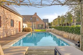 Deze ruime woning is gelegen op een prachtig perceel van 1.474 m² met een praktisch bijgebouw van maar liefst 75 m², een ingebouwd zwembad en een poolhouse. De woning profiteert van een gunstige ligging met Balen - Centrum op slechts 1,5 km en een groene omgeving met o.a. de Keiheuvel. <br /><br />De woning werd gebouwd in 2000 met aandacht voor een praktische indeling, aangenaam veel lichtinval en ruimte. We betreden de woning via de ruime inkomhal met toegang naar de bureauruimte en de leefruimte. De bureauruimte kan ideaal ingericht worden als ontvangstruimte, werkplaats of extra kamer. De ruime leefruimte (45m²) is opgesplitst in een eethoek en zithoek en is voorzien van bekabeling voor een surround systeem. Aansluitend bevindt zich de keuken voorzien van een koelkast, inductiekookplaat, afzuigkap, vaatwasser, stoomoven, lavabo en koffiemachine. Hier bevindt zich tevens ruimte voor een eettafel met een prachtig zicht naar de tuin. Ook de badkamer bevindt zich op het gelijkvloers en is uitgerust met een inloopdouche en dubbele wastafel in meubel. <br />Het is dus mogelijk om volledig gelijkvloers te leven! <br /><br />Achteraan de woning bevindt zich de achterinkomhal met doorgang naar de tuin, het gastentoilet en de ruime (verwarmde) garage. <br /><br />De vier slaapkamers en extra berging bereikbaar op de eerste verdieping zijn bereikbaar via de charmante vaste trap. <br /><br />In de tuin geniet je tijdens de zomermaanden optimaal dankzij het ingebouwd zwembad met bijhorende poolhouse. Dit poolhouse is de ideale plaats om te genieten van de zon dankzij o.a. het zongeoriënteerde terras. Binnenin is deze afgewerkt met een verwarmde zithoek, badkamertje (douche en toilet) en keukentje. <br /><br />Het praktische bijgebouw van 75 m² is momenteel ingericht als garage maar kan ook prima anders benut worden. Hier zijn tal van mogelijkheden.<br /><br />* EPC A-label ! <br />* vloerverwarming<br />* 33 zonnepalen (10.890 Wp)<br />* inpandige garage + grote garage/ bijgebouw met alle voorzieningen <br />* verwarmd zwembad<br />* alarmsysteem<br />* zeer veel parkeermogelijkheden