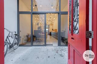 AALST - Karaktervol pand met kantoor/praktijkruimte en vernieuwd triplexappartement<br /><br />Wonen en werken combineren op een topligging in het centrum van Aalst? Dit kwalitatieve en energiezuinige pand, gelegen aan de Gentsestraat, biedt een unieke combinatie van een volwaardige kantoor- of praktijkruimte op het gelijkvloers en een ruim, vernieuwd triplexappartement op de verdiepingen.<br /><br />Op het gelijkvloers bevindt zich een volledig onafhankelijke kantoor- of praktijkruimte van ongeveer 55 m². De inrichting is praktisch en eigentijds, met onder meer vloerverwarming via warmtepomp en een kitchenette. Achteraan is er bovendien een aangename koer of terras. Een kelderruimte biedt extra mogelijkheden als archief- of bergruimte. Verder beschikt de kantoorruimte over twee afzonderlijke toiletten met daartussen een lavabo.<br /><br />De bovenliggende verdiepingen vormen samen een ruim en vernieuwd triplexappartement. Op de eerste verdieping komt u terecht in een aangename en lichtrijke leefruimte, waar de ingerichte keuken centraal werd geplaatst. Vooraan bevindt zich een ruime eetkamer, terwijl de woonkamer zich achteraan bevindt en dankzij de grote glaspartij volop geniet van natuurlijk licht en rechtstreeks toegang geeft tot het eerste terras. Aansluitend aan de keuken is er nog een praktische berging/wasplaats.<br />Op de tweede verdieping bevinden zich twee volwaardige slaapkamers. Eén van beide kamers beschikt opnieuw over een aangenaam zonneterras. De badkamer bevindt zich centraal tussen de slaapkamers en is uitgerust met zowel een bad als een douche.<br />De bovenste verdieping biedt nog een derde slaapkamer. Deze ruimte kan ook perfect worden ingericht als hobbykamer, bureau of polyvalente ruimte, afhankelijk van de noden.<br /><br />Ook op technisch vlak heeft deze woning heel wat troeven. De eigendom is goed geïsoleerd en beschikt over HR-beglazing en aluminium ramen. De verwarming gebeurt via een warmtepomp in combinatie met zonneboilers en vloerverwarming. Daarnaast is de elektrische installatie conform en zijn er afzonderlijke tellers aanwezig.<br /><br />De combinatie van een zelfstandige kantoor- of praktijkruimte met een ruime woning maakt deze eigendom bijzonder geschikt voor zelfstandigen, vrije beroepen of ondernemers die wonen en werken graag op één centrale locatie willen combineren. Tegelijk biedt de indeling interessante mogelijkheden voor wie op zoek is naar een investering met verhuurpotentieel.<br /><br />Voor meer informatie of een bezoek kunt u contact opnemen via 053/60.65.60.