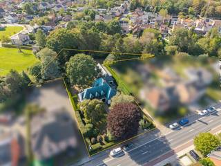 Op een uitstekende locatie te Berlaar bevindt zich deze ruime gezinswoning met vijf slaapkamers, zwembad en handelsruimte, gelegen op een mooi perceel van maar liefst 33a 83ca. Dankzij de gunstige ligging bevinden winkels, scholen, horeca en het openbaar vervoer zich op wandelafstand, terwijl u thuis geniet van rust en ruimte.<br /><br />We betreden de woning via de inkomhal, voorzien van een vestiaire en gastentoilet. De lichtrijke leefruimte wordt gekenmerkt door de vele raampartijen en biedt alle ruimte voor een gezellige zithoek en aparte eetplaats. De keuken sluit mooi aan op de leefruimte en is uitgerust met de voornaamste toestellen. Naast de keuken bevindt zich nog een ruimte die kan ingericht worden als bureau/zithoek/eetplaats. Via deze extra leefruimte komen we terecht bij het overdekt terras, met zicht op de tuin. Ook buiten heeft deze woning heel wat te bieden. De volledig aangelegde tuin met zwembad vormt een heerlijke, groene oase waar u in alle rust en privacy kunt genieten van het buitenleven en mooie zomerdagen. Aan parkeergelegenheid is er evenmin een gebrek. De woning beschikt over een ruime oprit en een inpandige garage met aanpalende bergruimte. En hier stopt het nog niet, want het gelijkvloers heeft nog enkele verrassingen. Er is een aparte ingang aanwezig die toegang geeft tot een handelsruimte, op de eerste verdieping, van maar liefst 83m². Deze ruimte zou ingericht kunnen worden als studio. Ook vooraan de woning is er een extra kamer voorzien die kan ingericht worden als handelsruimte of als gelijkvloerse slaapkamer met berging, douchekamer en apart toilet. Via de prachtige trappenhal komen we in de nachthal van de eerste verdieping terecht. Deze geeft ons toegang tot 4 ruime slaapkamers, aparte toiletruimte en de badkamer, voorzien van dubbele lavabo en ligbad. De woning beschikt tevens over een kelder- en zolderruimte.<br /><br />Dit is een uitstekende opportuniteit als u op zoek bent naar een ruime villa met vijf slaapkamers en eventuele handelsruimte op een groen perceel te Berlaar. Contacteer ons voor meer informatie op 0472 82 80 66 of neem een kijkje op www.boonstravastgoed.be. <br /><br />Bijzonderheden: <br />- 5 slaapkamers<br />- Bewoonbaar oppervlakte 617 m²<br />- Ruim perceel 3383m² met zwembad