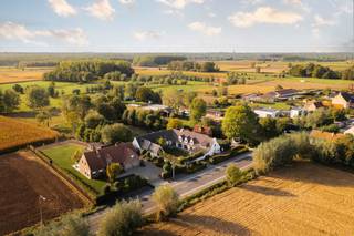 <div>LIGGING<br /><br />Deze villa is gelegen in het landelijke Laarne op een perceel van 5 336m2 met een goede 700M2 bewoonbare oppervlakte alsook een bijgebouw van 80m2 die veel mogelijkheden te bieden heeft.<br />De regio is rijk aan wandel- en fietsroutes alsook vlot bereikbaar met de wagen met de nabijheid van diverse invalswegen.<br /><br />VILLA<br /><br />De oorspronkelijke villa dateert van 1981, de landelijke architectuur is eveneens terug te vinden binnenin deze woning.<br />Deze villa is perfect voor wie wonen én werken wil combineren.<br /><br />Parallel aan de straat hebt u de hoofdingang van de villa. De villa komt u binnen via de ruime inkomhal met gastentoilet daarbij aansluitend hebt u het eerste deel van de woning. Kenmerkend aan de authentieke vloeren, balken en open haard zijn er gezellige ruimtes zoals eetkamer en living terug te vinden.<br />Vanuit de volledig nieuw geïnstalleerde, luxueus afgewerkte keuken, alsook de leefruimte en de eetkamer geniet u de connectie met zowel de voor- als de achtertuin, de kwalitatieve afwerking en lichtinval in deze ruimtes springt onmiddellijk in het oog.</div>
<div>De keuken is voorzien van een kwartsiet werkblad en volledige uitgewerkt in volle eik. Er werd gekozen voor een combinatie van MIELE en AEG toestellen.</div>
<div><br />Op de gelijkvloerse verdieping zijn er nog enkele technische en praktische ruimtes zoals, een bijkeuken, wasplaats, ruimte met technieken voor het zwembad, een extra doucheruimte en toilet.<br /><br />Boven zijn er 7 slpk waarvan de masterbedroom een prachtig zicht op de tuin en de achterliggende velden geniet.</div>
<div>De badkamer bij de master bedroom is uitermate hoogstaand afgewerkt, alles is tot in de puntjes uitgewerkt in de mortex en er werd gekozen voor prachtige verlichting. <br /><br />Één van de troeven van deze villa is de goed georiënteerde tuin voorzien van zwembad met een uniek zicht op de velden.<br />Info of een bezoek 0472 01 51 51.</div>