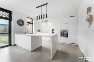 Op zoek naar een ruime, recente (bouwjaar 2022) én energiezuinige woning? Deze instapklare gezinswoning biedt maar liefst 229 m² bewoonbare oppervlakte op een perceel van 325 m² en combineert hedendaags wooncomfort met een praktische indeling.<br /><br />Bij het binnenkomen wordt u verwelkomd in een inkomhal met gastentoilet die toegang geeft tot de  lichtrijke leefruimte met grote raampartijen.<br /><br />De leefruimte gaat naadloos over in de open keuken met stijlvol keukeneiland. De keuken vormt het hart van de woning en biedt alle ruimte voor gezellige familiemomenten en etentjes met vrienden.<br /><br />Aansluitend bevindt zich een ruime wasberging/voorraadkamer, ideaal voor extra opslag en een georganiseerde huishouding.<br /><br />De woning beschikt over vier volwaardige slaapkamers, waaronder een master bedroom met eigen dressing. Daarnaast zijn er twee comfortabele badkamers, wat zorgt voor optimaal wooncomfort voor het hele gezin.<br /><br />Een absolute troef is de zeer ruime zolderverdieping met vaste trap, die tal van mogelijkheden biedt als hobbyruimte, extra opslag of toekomstige uitbreiding.<br /><br />Buiten geniet u van een aangename tuin met een deels overdekt terras, waar het heerlijk vertoeven is in elk seizoen. De woning beschikt bovendien over een carport met buitenberging en voldoende parkeergelegenheid op eigen terrein.<br /><br />Ook op technisch vlak scoort deze woning uitstekend:<br />•	Gekeurde elektrische installatie<br />•	Kwalitatieve afwerking <br />•	8 zonnepanelen<br />•	Asbestvrij<br />•	Zeer energiezuinig karakter (BEN -woning – E29 – label A)<br /><br />Kortom, een ruime en perfect onderhouden woning met alle comfort, energiezuinigheid en ruimte die een modern gezin zich kan wensen.<br /><br />