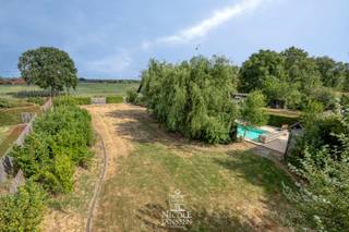Dit mooi landhuis met verwarmd zwembad en poolhouse is verrassend ruim ingedeeld. Extra praktisch zijn de grote carport en de dubbele garage met vliering. <br />Het bijzonder gunstige EPC (B-label), de goedgekeurde elektra, zonnepanelen,... zijn maar enkele van de vele troeven van deze landelijke woning. Het huis is omringd door veel groen en het naastgelegen bosperceeltje van ruim 50 are is ook inbegrepen. <br /><br />=> Ligging<br />Gelegen in het landelijke Molenbeersel vlakbij de Nederlandse grens, waar rust, natuur en ruimte centraal staan. Je geniet hier van een groene woonomgeving met tal van wandel- en fietsmogelijkheden, terwijl andere voorzieningen zich op korte afstand bevinden. Dankzij de vlotte verbinding naar Maaseik, Bree en Nederland is dit een ideale locatie voor wie rustig wil wonen zonder in te boeten aan bereikbaarheid. <br /><br />=> Gelijkvloers <br />- Inkomhal/gang met toegang tot de verschillende ruimtes<br />- Luchtige L-vormige woonkamer met mooie parketvloer<br />- Doorzonkamer met vrij uitzicht over de weilanden aan de overzijde<br />- Gezellige inbouwhaard die op frisse avonden voor een warme sfeer zorgt<br />- Open keuken, voorzien van veel kastruimte en alle denkbaar comfort<br />- De leefkeuken ligt centraal tussen de woonkamer en de zonnige tuinkamer aan de achterzijde<br />- Tuinkamer/veranda met zicht op en toegang tot buiten<br />- Grote tussenruimte met veel lichtinval en toegang naar zowel de praktische wasplaats als naar de tuin<br />- Deze ruimte kan naar wens ingericht worden maar biedt veel mogelijkheden<br />- Ouderlijke slaapkamer met airco<br />- Rechtstreeks toegang naar de ingerichte dressing vanuit deze slaapkamer<br />- Complete badkamer voorzien van grote inloopdouche en dubbele wastafel in landelijk meubel<br />- De badkamer is eveneens voorzien van toilet en bidet en heeft vloerverwarming<br />- Bureel/kleine slaapkamer <br /><br />=> Verdieping<br />- Via de overloop met extra opbergruimte is er toegang tot de twee grote slaapkamers boven en het toilet<br />- Slaapkamer met inbouwkasten in zijwanden<br />- Tweede slaapkamer/hobbyruimte voorzien van airco en zicht over de tuin<br /><br />=> Tuin<br />- Fantastisch overdekt terras met zicht over het verwarmd zwembad met nieuw roldek<br />- Terras met praktische buitenkeuken<br />- Genieten van vakantie aan huis kan hier in alle privacy<br />- Zowel links als rechts van het huis is er nog een groot stuk tuin waardoor er een enorm gevoel van vrijheid is<br />- Volledig omheind terrein<br />- Nieuwe grote dubbele carport<br />- Tevens een dubbele inpandige garage met grote vliering erboven<br />- De grote achtertuin is ideaal voor spelende kinderen, huisdieren of gewoon voor iedereen die houdt van veel groen rondom<br />- Het bosperceel van ruim 50 are links van de woning is eveneens inbegrepen<br /><br />=> Indeling<br />-- Gelijkvloers: centrale hal, L-vormige woonkamer, leefkeuken, tuinkamer/veranda, nachtgang, ouderlijke slaapkamer met eigen dressing, bureel/kleine slaapkamer, badkamer met toilet, wasplaats, grote tussenruimte en dubbele garage met vliering;<br />-- Verdieping: overloop met bergruimte, toilet en twee grote slaapkamers/hobbyruimtes;<br />-- Poolhouse en verwarmd zwembad;<br />-- Grote dubbele carport