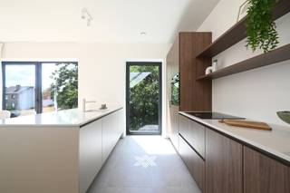 Dit lichtrijke duplex appartement is ideaal gelegen op de eerste en tweede verdieping en geniet er van een prachtig uitzicht op de parktuin en het omliggende groen. De ruime terrassen bieden de hele dag zon en bieden unieke zichten op de nieuwe parktuin waarbij de bestaande, inheemse waardevolle bomen blijven behouden. Het appartement beschikt over drie slaapkamers, een badkamer met ligbad, inloopdouche en lavabo, twee toiletten, een voldoende ruime berging en een bijzonder lichtrijke leefruimte met open keuken, eet- en zithoek. Via beide schuiframen is er een directe toegang tot de zonneterrassen van samen 24m². <br /><br />Ondergronds zijn er ruime parkings en handige bergingen voorzien. Tevens is er een vlot toegankelijke fietsenberging op het gelijkvloers. <br /><br />Het gebouw onderscheidt zich naast haar sublieme ligging en hoogstaande architectuur, door haar lage energiefactuur en duurzaam karakter. Zo krijgt u een combinatie van vloerverwarming met warmtepompen en een sterke akoestische en thermische isolatie. Bovendien worden de appartementen uitgerust met een ventilatiesysteem met warmterecuperatie.<br /><br />Verlaagd BTW-tarief van 6% mogelijk op de volledige constructiewaarde. <br /><br />Benieuwd naar dit rustig gelegen project vlakbij het centrum van Merelbeke? Van harte welkom voor een individuele rondleiding.