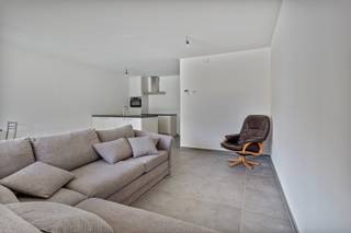 Nieuwbouw appartement onder registratierechten (2% of 12%) ! <br /><br />Dit prachtige, recent gelijkvloers appartement met 1 slaapkamer en een gezellig tuintje bevindt zich op wandelafstand van het centrum en heeft een uitstekende verbinding met de omliggende gemeenten.<br /><br />Bij binnenkomst via de inkomhal, die een vestiaire en gastentoilet biedt, komt u in leefruimte met een open keuken. Deze keuken is uitgerust met kwalitatieve toestellen, zoals een koelkast, vaatwasser, combi-oven, inductiekookplaat, afzuigkap en spoeltafel, en biedt voldoende opbergruimte. De berging naast de keuken kan praktisch worden ingedeeld. Door het grote schuifraam bereikt u de zonovergoten tuin met een gezellig overdekt terras. De tuin is volledig omheind en toegankelijk via het achterliggende fietspad.<br /><br />Het appartement beschikt over een ruime slaapkamer, waarin grote kasten makkelijk kunnen worden geplaatst. De aangrenzende badkamer is voorzien van een betegelde inloopdouche en een wastafel in meubel.<br /><br />Het gebouw is energiezuinig en uitgerust met een ventilatiesysteem type D, een warmtepomp, zonnepanelen en vloerverwarming.<br /><br />Als extra voordeel is er een ruime autostaanplaats met laadpaal in de kelder, evenals een privatieve berging aan de achterkant van het perceel. Deze zijn verplicht bij te kopen aan € 20.000.