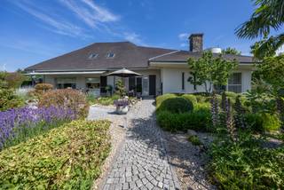 Deze charmante villa is uitstekend gelegen op een vlot bereikbare locatie, op korte afstand van het centrum van Oostmalle. Hier geniet u van een ideale combinatie van rust, ruimte en bereikbaarheid. Bovendien bestaat de mogelijkheid om de achtergelegen weilanden bijkomend aan te kopen.<br /><br />INDELING:<br /><br />Via de mooie oprit bereikt u de woning. Bij het binnenkomen wordt u verwelkomd in een ruime inkomhal. Rechts bevindt zich de lichtrijke leefruimte, die dankzij de vele raampartijen geniet van een aangename lichtinval en een prachtig uitzicht biedt op de fraai aangelegde tuin. Aansluitend bevindt zich de volledig uitgeruste keuken, die rechtstreeks toegang verleent tot het gezellige terras.<br /><br />Links van de inkomhal bevindt zich het slaapgedeelte. De woning beschikt over drie ruime slaapkamers en twee comfortabele badkamers. De eerste badkamer is uitgerust met een enkele lavabo, een ligbad en een toilet. De tweede badkamer beschikt over een dubbele lavabo en een inloopdouche. Via deze badkamer bereikt u bovendien een praktische bureauruimte, een wasplaats en een extra toilet.<br /><br />Verder beschikt de woning over een ruime bergzolder, wat zorgt voor extra opslagmogelijkheden.<br /><br />Buiten geniet u van een prachtig aangelegde, volledig omheinde tuin waar u in alle rust kunt ontspannen. Achter de afsluiting bevindt zich nog een extra perceelsgedeelte met een garage, een opslagplaats en een ruim magazijn. Deze bijkomende gebouwen bieden tal van mogelijkheden voor hobbyisten, zelfstandigen of wie op zoek is naar extra bergruimte.<br /><br />Kortom, een ruime en veelzijdige woning met een uitstekende ligging, ideaal voor gezinnen of wie wonen en werken wenst te combineren.<br /><br />BIJZONDERHEDEN: <br />- Goede bereikbare locatie<br />- Veel mogelijkheden <br />- Veel ruimte<br />- Aangelegde tuin<br /><br />Voor meer info of een bezoek ter plaatse kan u vrijblijvend contact opnemen met Lieselotte op 03.227.58.58 of lieselotte@reds.be.
