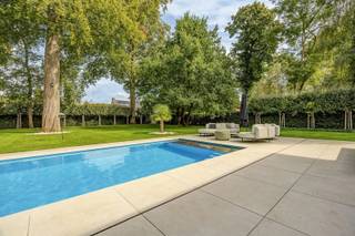 <h3><span>Ruime villa met zwembad in villapark De List</span></h3><p><span>In het rustige en groene </span><span>villapark De List</span><span> in Schoten vinden we deze ruime, volledig gerenoveerde stijlvilla. De woning werd in 2009 grondig vernieuwd met duurzame materialen en biedt dankzij de aparte inkom heel wat mogelijkheden als </span><span>kangoeroewoning, vrij beroep of kantoor aan huis</span><span>.</span></p><p><span>De inkomhal beschikt over een vestiaire en gastentoilet en geeft toegang tot bureau, technische ruimte, wasplaats en dubbele garage. De royale leefruimte met blauwe hardsteen en open haard loopt door in de volledig uitgeruste leefkeuken. Samen goed voor ca. </span><span>110 m² leefruimte</span><span>, met een gezellige bowwindow-eethoek.</span></p><p><span>Op de verdieping bevinden zich </span><span>4 ruime slaapkamers</span><span>, waaronder een master met dressing en ensuite badkamer met jacuzzi en inloopdouche. Daarnaast zijn er nog 3 badkamers, waarvan 2 met jacuzzi.</span></p><p><span>Buiten geniet je van een </span><span>zuidwestgerichte tuin</span><span> met volwassen bomen, terrassen en een </span><span>nieuw groot zwembad</span><span>. De ruime voortuin biedt parkeergelegenheid voor meerdere wagens.</span></p><p><span>De ligging is rustig én centraal. Via wandel- en fietsweggetjes bereik je vlot winkels en openbaar vervoer. Ook scholen, de grens met Brasschaat en het </span><span>Peerdsbos</span><span> bevinden zich in de omgeving.</span></p><p><span>Troeven:</span></p><ul><li><span>Volledig gerenoveerde stijlvilla (renovatie tussen 2009 en 2025) </span></li><li><span>4 slaapkamers & 4 badkamers </span></li><li><span>Kangoeroewoning / vrij beroep mogelijk </span></li><li><span>Ca. 110 m² leefruimte </span></li><li><span>Dubbele garage </span></li><li><span>Zuidwestgerichte tuin </span></li><li><span>Nieuw zwembad </span></li><li><span>Rustige, groene ligging </span></li></ul><p><span> </span></p><p><span>Ontdek deze veelzijdige villa tijdens een bezoek. Contacteer ons via 03 646 66 55 of info@sinjoor.be.</span></p>