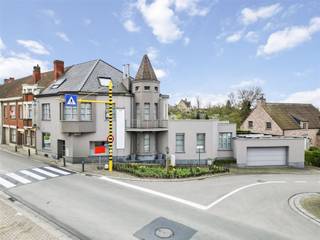 <p><span>Ontdek deze unieke herenwoning met commerciële mogelijkheden in hartje Anzegem</span></p><p><span>Bent u op zoek naar een woning waar wonen en werken in harmonie kunnen samenkomen? Deze charmante herenwoning in het centrum van Anzegem biedt u die kans! De woning beschikt over een prachtig commercieel gedeelte dat uitermate geschikt is als praktijkruimte, winkel of kantoor, met een duidelijke scheiding tussen het woon- en werkgedeelte. De centrale ligging is een absolute troef voor wie wonen en werken wil combineren.</span></p><p><span>Indeling en comfort</span><span> Bij het binnenkomen voelt u meteen de luxe en de aandacht voor detail. De ruime woonkamer is opgedeeld in een zit- en eetruimte en geniet van overvloedig daglicht dankzij de grote raampartijen. Aansluitend vindt u de volledig uitgeruste, tijdloze keuken met keukeneiland, ideaal voor de kookliefhebbers onder ons. Vanuit de keuken heeft u zicht op de onderhoudsvriendelijke, omheinde tuin en toegang tot het terras en de kelderverdieping.</span></p><p><span>De woning biedt tevens een grote garage met ruimte voor twee wagens, een berging, een aparte wasplaats en een gastentoilet op de benedenverdieping.</span></p><p><span>Via een gerestaureerde eiken trap bereiken we de eerste verdieping met drie ruime slaapkamers, waaronder een masterbedroom met erker en een luxueuze badkamer met losstaand bad, douche en dubbele lavabo. Een tweede badkamer met douche, toilet en wastafel vervolledigt deze verdieping. De tweede verdieping biedt nog twee slaapkamers, elk uitgerust met een eigen bureau en inbouwkasten.</span></p><p><span>Tuin en buitenruimte</span><span> De onderhoudsvriendelijke tuin is een oase van rust en biedt zowel groen als een betegeld terras, ideaal voor gezellige momenten met familie of vrienden. De tuin is toegankelijk via de keuken en een naastgelegen straat, en bevat een buitenberging.</span></p><p><span>Extra troeven</span></p><ul><li><span>Geen renovatieplicht</span></li><li><span>Zonnepanelen</span></li><li><span>Driedubbele beglazing</span></li><li><span>Airco in het commerciële gedeelte</span></li><li><span>Hoogwaardige materialen en afwerking</span></li></ul><p><span>Interesse? Neem dan snel contact met ons op via info@immovanparijs.be of bel ons op 056/29.30.30. Onze medewerkers staan klaar om u deze unieke woning te laten ontdekken. Wie weet wordt dit binnenkort uw nieuwe thuis en werkplek in één!</span></p><p><span><br /><br /></span></p>