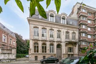 Statig gebouw op residentiële locatie nabij Albertpark<br /><br />Voormalig herenhuis uit 1900 in Neorégencestijl met een monumentale façade is afgewerkt met mansardedak en witte natuursteen en herbergt momenteel royale kantoorruimtes. Een golvend balkon met consoles en sierlijke smeedijzeren borstwering sieren de gevel.<br /><br />Dubbele houten deur geeft toegang tot het eigendom. Een centrale trapzaal met prachtige lichtinval via de lichtkoepel verbindt de verscheidene vertrekken. Het originele schrijnwerk in combinatie met parketvloeren en hoge plafonds geven authenticiteit en eigenheid. Twee ruime aaneensluitende kamers worden verbonden door een majestueuze openslaande deur met glazen invulling, voorzien van ijzeren smeedwerk en ingebouwde opberging. Grote raampartijen in de achterkamer bieden zicht op volgroeide bomen en toegang tot de buitenruimte.<br />Vervolgens leidt de trap naar de verdiepingen die telkens onderverdeeld zijn in verschillende kantoren en voorzien van sanitair. Authentieke elementen werden behouden.<br /><br />Het gebouw is tevens volledig onderkelderd.<br /><br />Er bevinden zich ruime parkeerfaciliteiten op het terrein. Het perceel is afgesloten door middel van een smeedijzeren inrijpoort met natuurstenen pijlers.<br /><br />Het gebouw is gelegen nabij verscheidene invalswegen met goede ontsluiting van en naar de stad met de wagen en openbaar vervoer.