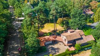 Nabij het kasteel van ’s-Gravenwezel bevindt zich deze karaktervolle Vlassak-Verhulstvilla, waar privacy, ruimte en groen harmonieus samenkomen. De omliggende natuur leent zich uitstekend voor wandelen, fietsen en sporten, terwijl de centra van ’s-Gravenwezel en Schilde zich op korte afstand bevinden. Ook scholen, winkels en openbaar vervoer zijn vlot bereikbaar. Een aangename combinatie van residentieel wonen en vlotte bereikbaarheid.<br /><br /><strong>Indeling</strong><br />Via de automatische toegangspoort bereikt u de villa langs de oprijlaan met voldoende parkeergelegenheid en een dubbele inpandige garage.<br /><br />De centrale inkomhal met vestiaire en gastentoilet geeft toegang tot verschillende vertrekken in de villa. De ruime woonkamer geniet dankzij de vele raampartijen van veel natuurlijk licht en een prachtig zicht over de tuin en terras. Aansluitend bevinden zich de eetkamer en keuken, die samen met de woonkamer rechtstreeks uitgeven op het zonnige terras. Een heerlijke plek voor lange diners, gezellige familiemomenten of het ontvangen van gasten.<br /><br />Naast de keuken bevindt zich een praktische wasplaats/berging met toegang tot de garage, het terras, de bergkelder en de wijnkelder. Het gelijkvloers beschikt daarnaast over twee polyvalente ruimtes, momenteel ingericht als bureau en speel-/hobbykamer, maar flexibel in te vullen volgens uw eigen woonbehoeften.<br />Een absolute troef is de master suite op het gelijkvloers, compleet met dressing, badkamer ensuite en toegang tot een eigen terras.<br /><br /><strong>Verdieping</strong><br />Op de eerste verdieping bevindt zich een tweede master bedroom met dressing en een gezellig privéterras. Daarnaast zijn er nog drie slaapkamers, twee badkamers en een afzonderlijk toilet.<br /><br /><strong>Tuin</strong><br />De zuidgeoriënteerde tuin vormt een prachtig verlengstuk van de woning en biedt verschillende plekken om doorheen de dag van de zon en het groen te genieten. Het overdekte terras met haard creëert een sfeervolle buitenruimte, terwijl het afzonderlijke multifunctionele bijgebouw/poolhouse bijkomende mogelijkheden biedt.<br />Tot slot beschikt de villa over praktische opbergzolders, een berg- en wijnkelder en een kruipruimte onder de volledige woning.<br /><br /><strong>Bijzonderheden</strong><br />+ Vlassak-Verhulstvilla<br />+ EPC: C<br />+ Elektriciteit conform<br />+ Gegeerde ligging nabij het kasteel van ’s-Gravenwezel<br />+ Zuidgeoriënteerde tuin<br />+ 5 slaapkamers en 3 badkamers<br />+ Master bedroom met dressing en badkamer op het gelijkvloers<br />+ Meerdere polyvalente ruimtes<br />+ Dubbele inpandige garage en ruime oprit