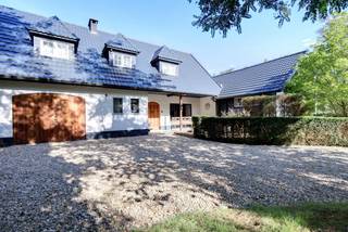 <p>Op zoek naar een <strong>unieke woning met ruimte, privacy en karakter</strong>, op slechts enkele minuten van het centrum? Deze bijzondere eigendom aan de Retieseweg in Geel biedt een uitzonderlijke combinatie van <strong>landelijk wonen, rust en veelzijdige mogelijkheden</strong>.</p>
<p>Gelegen op slechts <strong>ca. 5 km van de Grote Markt van Geel</strong>, geniet u hier van een groene en landelijke omgeving, terwijl u toch verzekerd bent van een vlotte verbinding met het centrum en de belangrijkste verbindingswegen.</p>
<p>Via een <strong>private oprijlaan</strong> bereikt u de charmante villa, gelegen op een prachtig en ruim domein van maar liefst <strong>ca. 9.604 m²</strong>. De eigendom wordt gekenmerkt door haar authentieke uitstraling, open ruimte en het unieke karakter van de verschillende bijgebouwen en schuren.</p>
<p>Naast de woning bevindt zich een <strong>charmant chalet</strong>, dat tal van mogelijkheden biedt en momenteel perfect kan worden ingericht als <strong>gastenverblijf, B&B, kantoorruimte of hobbyruimte</strong>.</p>
<p><strong>Voor de paardenliefhebber:</strong></p>
<p>Dit unieke domein is volledig ingericht voor paarden- en dierenliefhebbers en biedt tal van mogelijkheden om wonen en het houden van dieren te combineren.</p>
<p>Naast de woning bevindt zich een <strong>paardenstal met twee ruime boxen</strong>, met rechtstreekse toegang tot de omliggende weides. De weides zijn volledig omheind en beschikken over een <strong>verlichte buitenpiste van 20 x 40 meter</strong>, ideaal voor training en recreatief en of profetioneel gebruik.</p>
<p>Achteraan op het perceel bevindt zich bovendien een <strong>authentieke schuur</strong> met een ruime stal en extra opslagmogelijkheden. Een afzonderlijk bijgebouw doet momenteel dienst als <strong>gezellige feestruimte</strong> en kan uiteraard ook voor andere doeleinden worden aangewend.</p>
<p>Er is daarnaast <strong>mogelijkheid om bijkomende stallen te realiseren</strong>, waardoor het domein nog verder kan worden afgestemd op de behoeften van paardenliefhebbers.</p>
<p>De woning, gelegen aan de <strong>Retieseweg 90 in 2440 Geel</strong>, is gelegen op percelen die gedeeltelijk in <strong>agrarisch gebied</strong> en gedeeltelijk in <strong>woongebied met landelijk karakter</strong> liggen.</p>
<p>Ook voor de verdere ontwikkeling van het domein zijn er interessante mogelijkheden. Zo kan onder meer gedacht worden aan de aanleg van een <strong>zwembad met poolhouse en/of bijkomende paardenstallen</strong> op het achterliggende perceel (perceel 0951/00T007).</p>
<p>De concrete ontwikkelingsmogelijkheden zijn evenwel afhankelijk van de geldende bestemmingsvoorschriften, de toegestane verhardingsgraad en de stedenbouwkundige voorschriften. Deze aspecten dienen voorafgaandelijk te worden onderzocht en afgestemd met de bevoegde instanties. Mogelijk kan het bovendien aangewezen zijn om de verschillende percelen kadastraal samen te voegen, zodat de beschikbare oppervlakte en de mogelijkheden inzake toegestane verharding optimaal kunnen worden benut.</p>
<p><strong>Alle hierboven vermelde ontwikkelingsmogelijkheden zijn indicatief en onder voorbehoud van de vereiste goedkeuringen. Een voorafgaand stedenbouwkundig onderzoek is noodzakelijk.</strong></p>