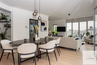 Op de bovenste verdieping van een architecturaal gebouw uit 2023, midden in de groene Tondelierwijk, bevindt zich dit uitzonderlijke penthouse waar ruimte, luxe, privacy en een adembenemend uitzicht over Gent centraal staan.<br /><br />Het appartement biedt 126,53 m² leefruimte en wordt omringd door maar liefst 113 m² terrassen. Grote raampartijen zorgen voor een prachtige lichtinval en weidse vergezichten over het park en de skyline van Gent. De terrassen vormen een echt verlengstuk van de leefruimte en laten u in alle privacy genieten van het buitenleven.<br /><br />Binnen wacht een royale leefruimte met hoge plafonds en parket, aansluitend op een luxueus afgewerkte keuken met kwalitatieve toestellen. Er zijn 2 slaapkamers, 2 badkamers, 1 apart toilet en een berging. Bovendien bestaat de mogelijkheid om een 3de slaapkamer of bureau te creëren.<br /><br />Vloerverwarming, warmtepomp, airco, zonnepanelen en zonnescreens zorgen voor optimaal comfort: EPC A+<br /><br />Extra troeven in het gebouw zijn 3 vaste fietsplaatsen en een gemeenschappelijke polyvalente ruimte met keuken, ideaal voor feestjes of bijeenkomsten.<br /><br />Winkels, scholen, sportcomplex en openbaar vervoer bevinden zich op wandelafstand, terwijl ook het historische centrum vlot bereikbaar is.<br /><br />Vraagprijs: € 898.000<br />Autostaanplaats optioneel aan te kopen aan € 50.000<br /><br />Een zeldzame combinatie van royaal buitenleven, luxueus wooncomfort en een prachtig uitzicht, vlak bij het hart van Gent.